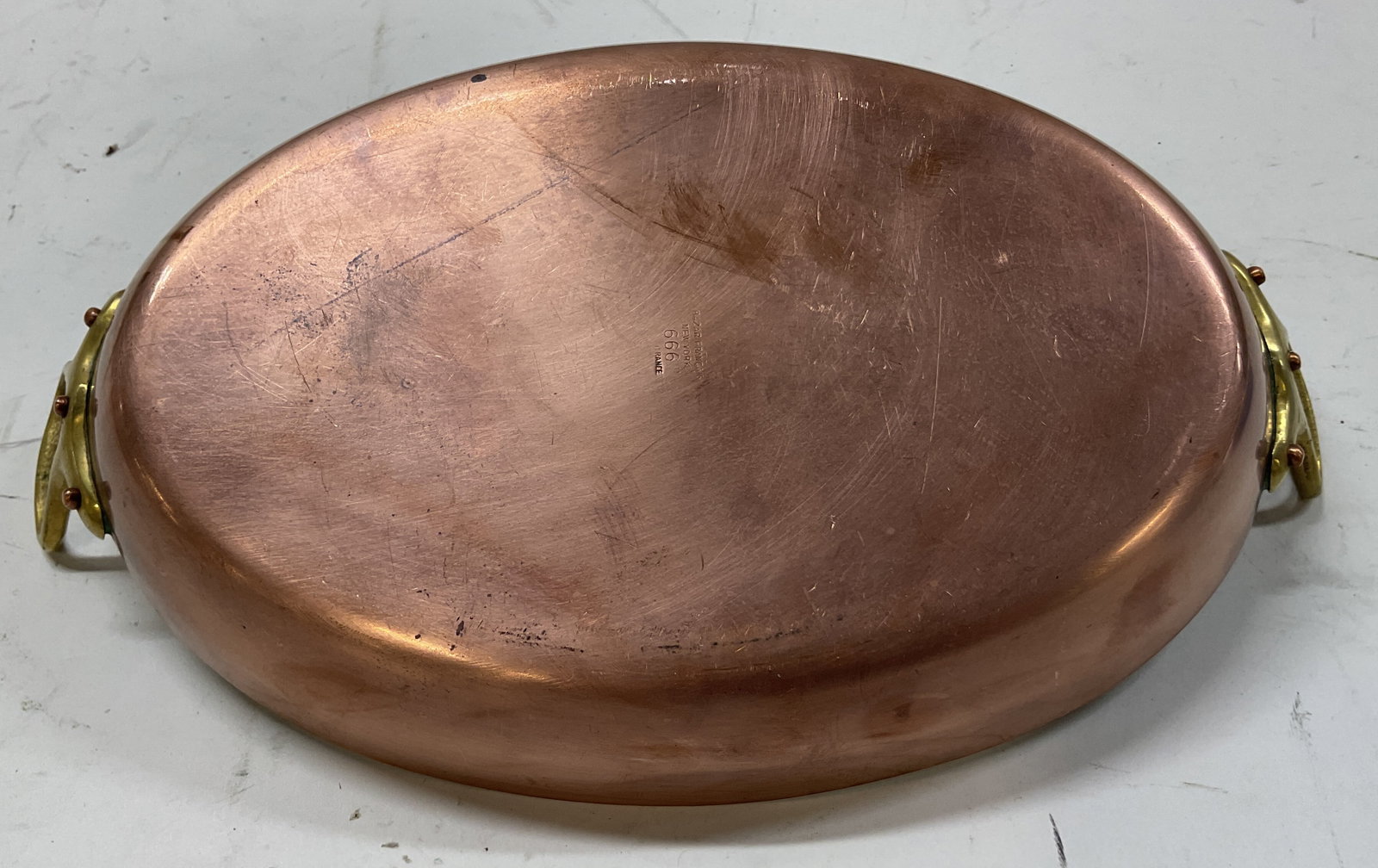 Bazar Francais Copper Handled Pan France: Bazar Francais copper handled pan. Marked on surface, reads Bazar Francais New York 666 France. Copper underside. Oval shaped. Handles on either side. Some weight. Measures approx 7 x 12 x 1.5