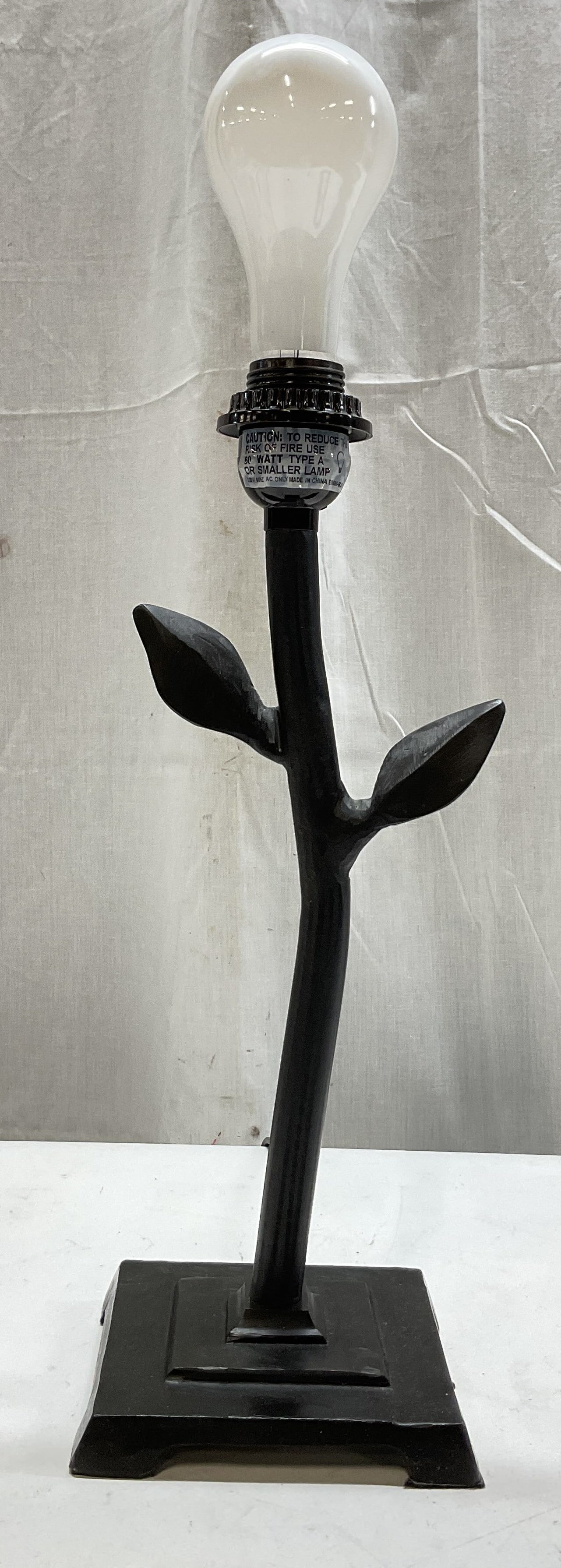 Vintage Black Metal Leaf Table Lamp: Vintage black metal leaf table lamp. Painted black stem and base. Footed square base with stepped design. Ornate stem with two leaf motifs. Soft carved details. Measures approx 5 x 5 x 18.5 inches. No