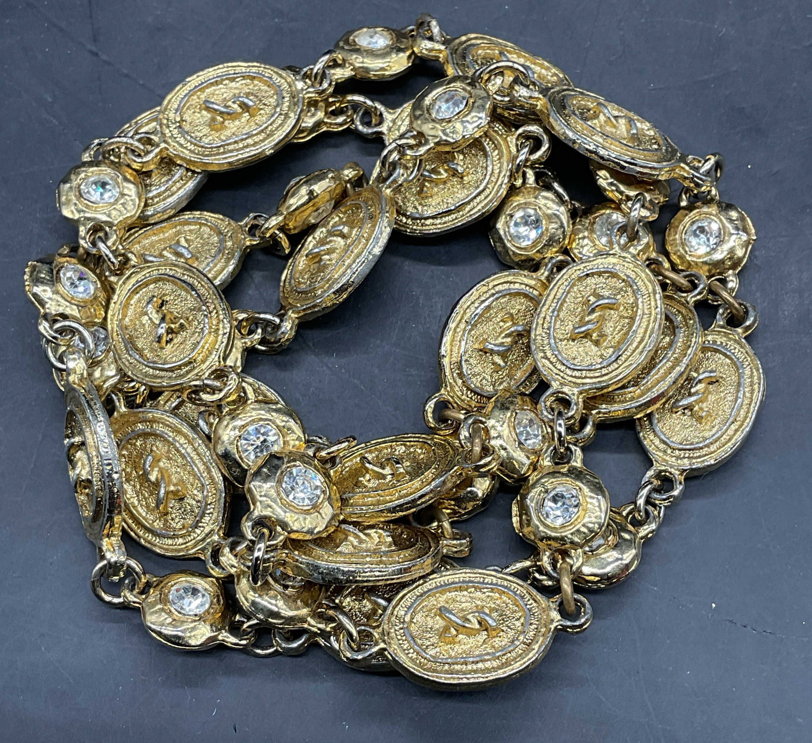 Vintage Gold Tone Medallion Crystal Necklace: Vintage gold tone necklace with alternating oval medallion panels and crystal panels. Style of Chanel, no markings. Drop length 18 inches. Includes a dust bag. Some scratching, loss to finish. Jewelry
