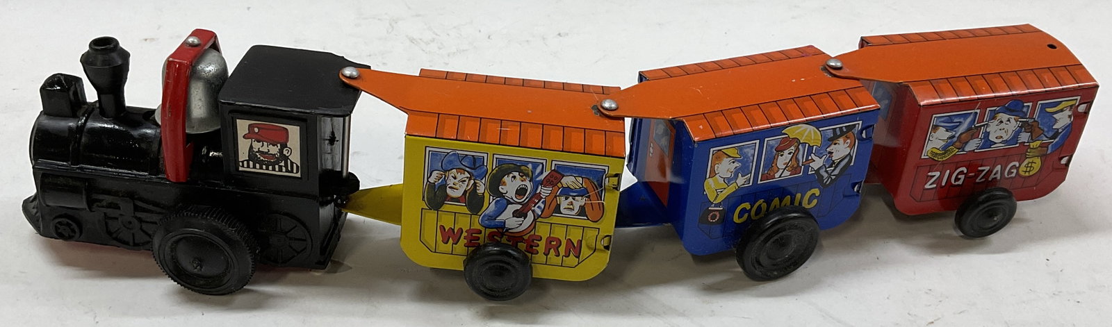 VTG MTU Comic Express Litho Tin Train Toy Korea: Vintage MTU Comic Express Litho Tin Wind-Up Train Toy. Features A Black Locomotive Followed by Colorful Cars with Western Comic Graphics and Bell Mechanism. Made in Korea. Some Scratching. Not Tested