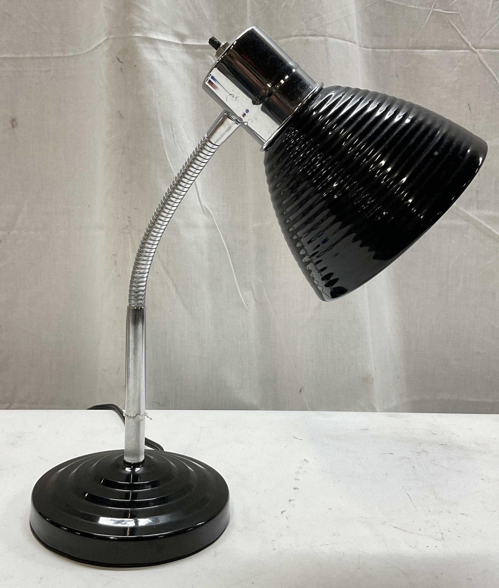 Vintage Black Metal Gooseneck Desk Lamp: Vintage black metal gooseneck desk lamp. Round base. Flexible arm that is adjustable. Ribbed shade. Measures ht approx 14.5 inches diam approx 6.5 inches. Not tested for function, sold as is. Surface