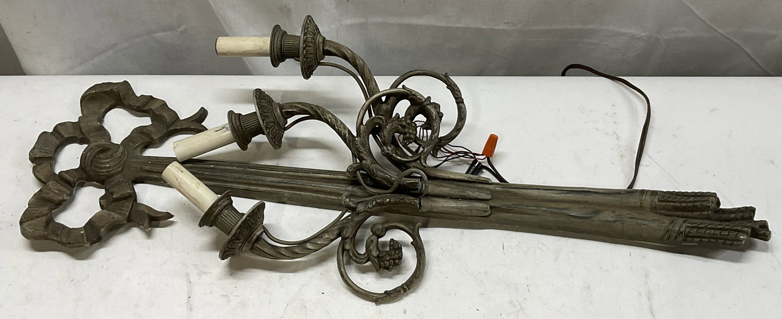 ATQ French Louis XVI Style 3-Arm Ribbon Sconce 28i: Antique French Louis XVI Style 3-Arm Ribbon Design Metal Wall Sconce. Aged Patina. Black, Brown, and Brass Toned. Wear to Metal and Coating Present. Arms are Detached. Not Tested for Functionality.