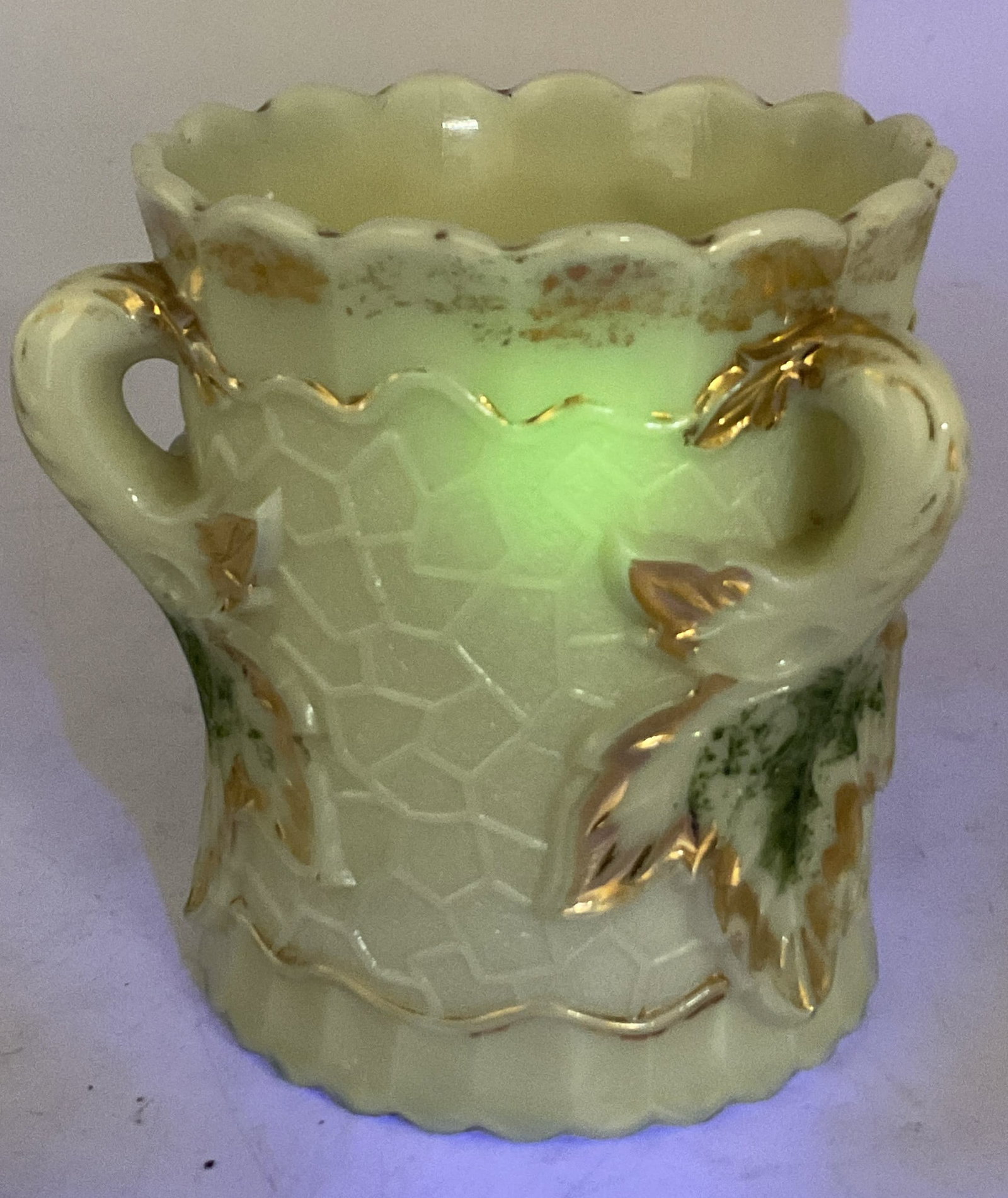Northwood Custard Uranium Glass Spooner Jar: Northwood custard uranium glass spooner jar. Scalloped edge. Three curved handles. Gilt trim. Leaf motifs, maple leaf pattern. Textured surface. Glows under UV light. Green accents. Measures ht