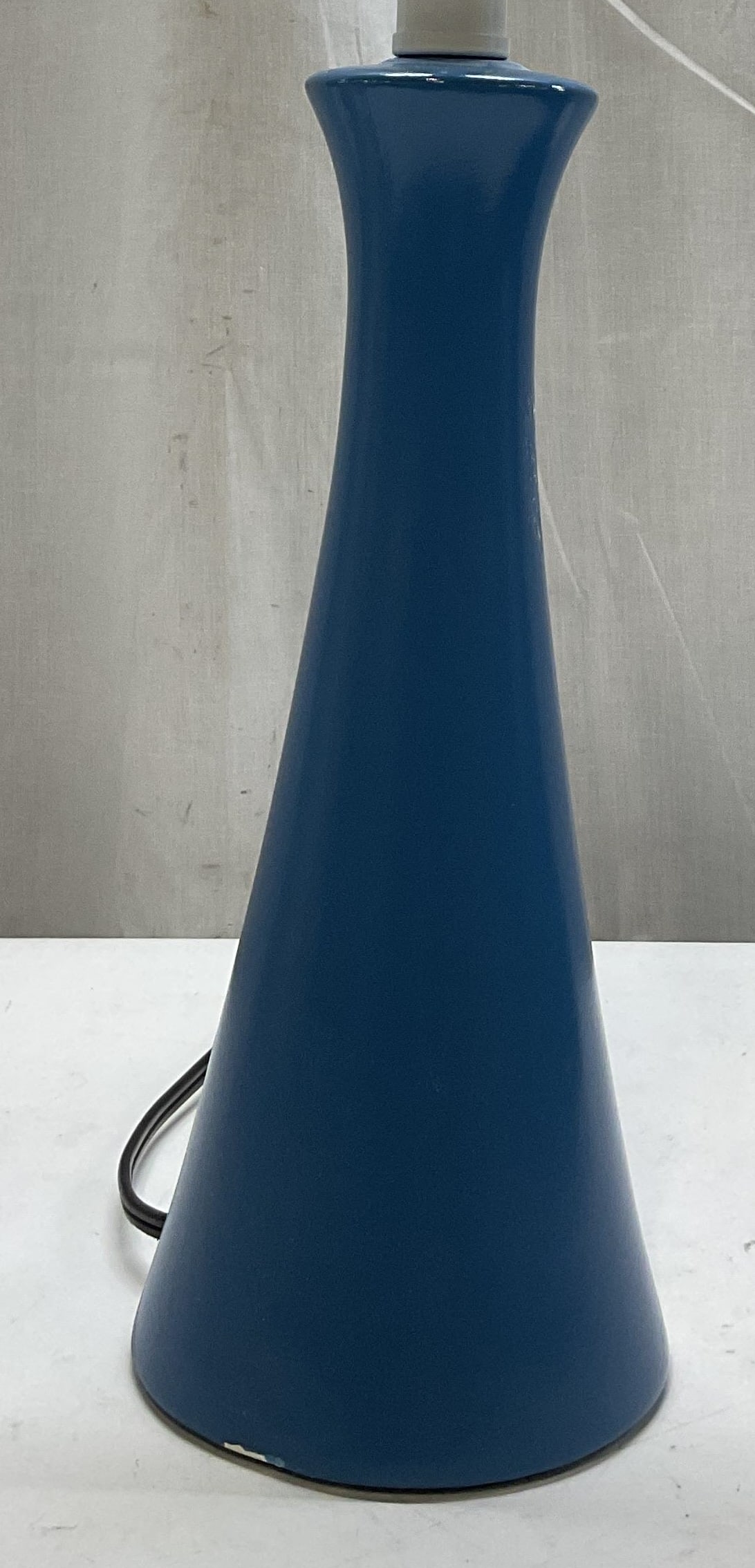 Vintage Blue Ceramic Table Lamp: Vintage blue ceramic table lamp. Hourglass shape, featuring a slender flared silhouette. Round base. Painted blue. Measures ht approx 20 inches diam approx 5 inches. Not tested for function, sold as