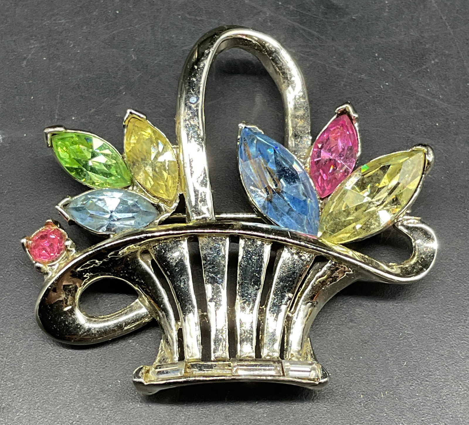 Silver Tone Rhinestone Flower Basket Brooch: Silver tone flower basket brooch with multicolored rhinestones. Measures approx. 2 x 1.5 inches. One rhinestone needs replacement. Some scratching. Jewelry, estate jewelry, costume jewelry, cocktail j