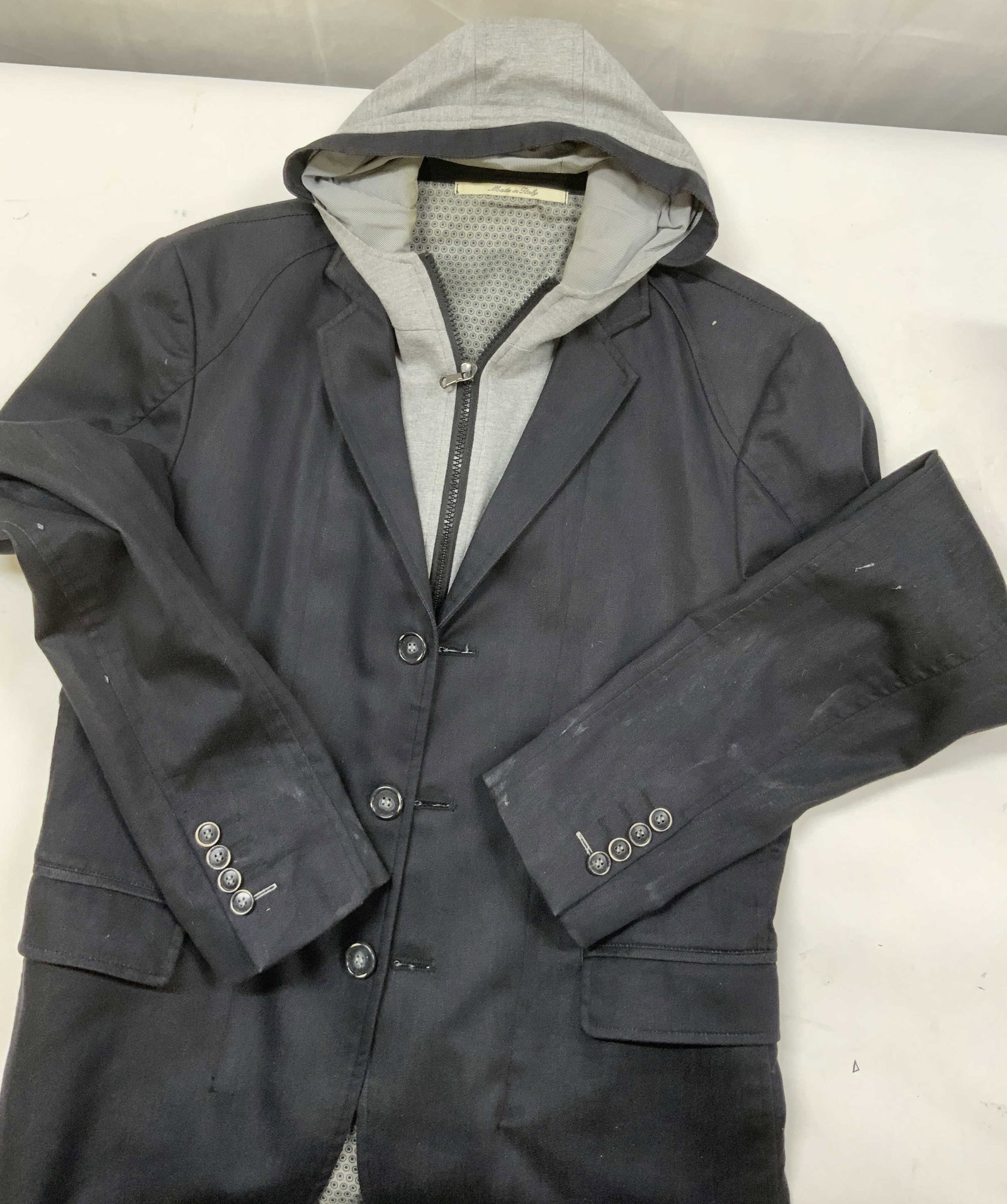 Vntg Resort Homme layered hybrid blazer. Italy: Vintage Resort Homme layered hybrid blazer. Made in Italy form a polyester cotton blend fabric. The outer shell has a formal silhouette of a structured single breasted tailored blazer, while the
