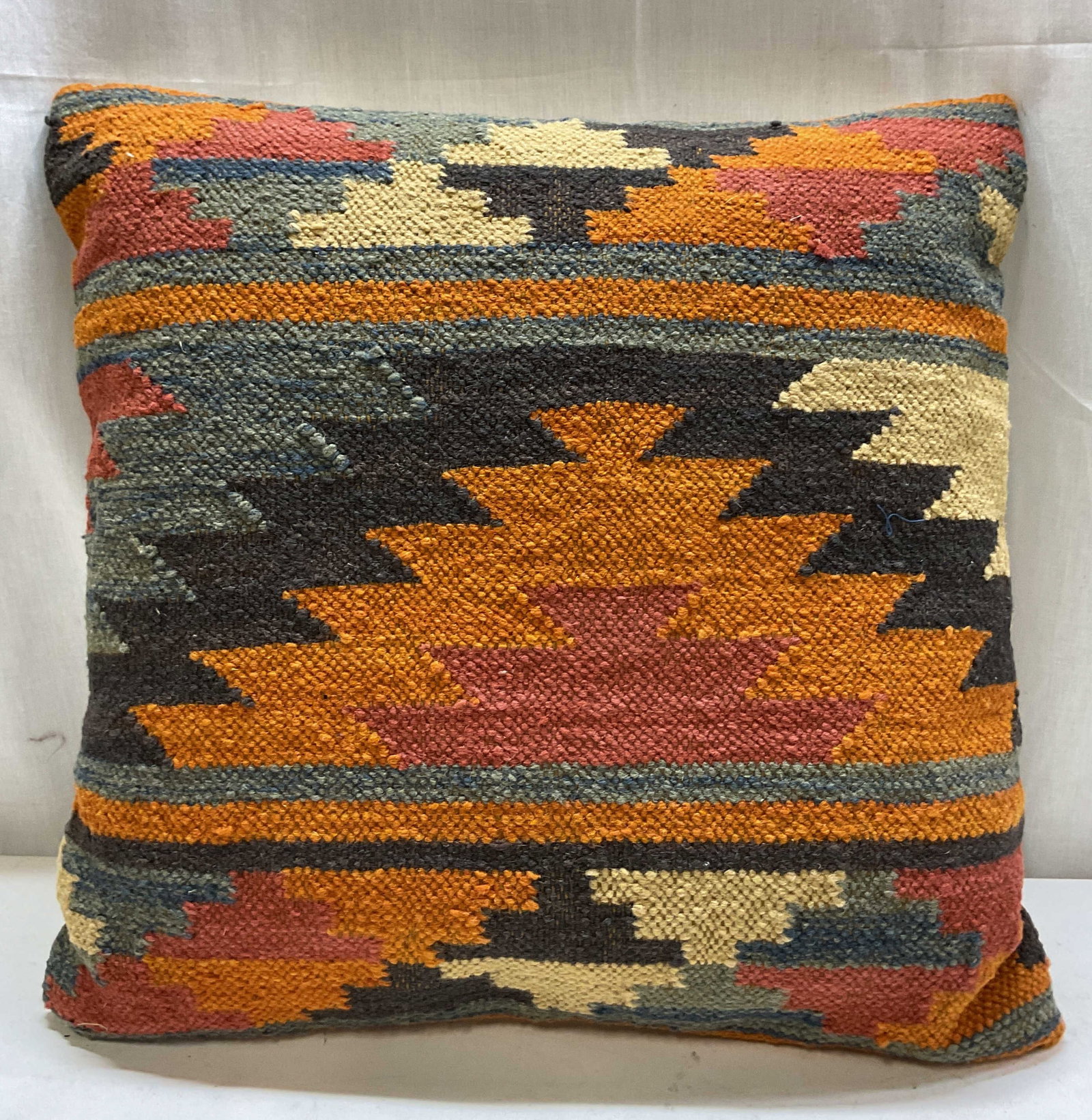 Vintage Turkish Wool Kilim Throw Pillow: Vintage Turkish wool Kilim throw pillow. Geometric tribal like pattern in orange, black, blue, red, etc. White back. Measures approx 20 x 21 inches. Surface wear consistent with exposure. Throw pillow