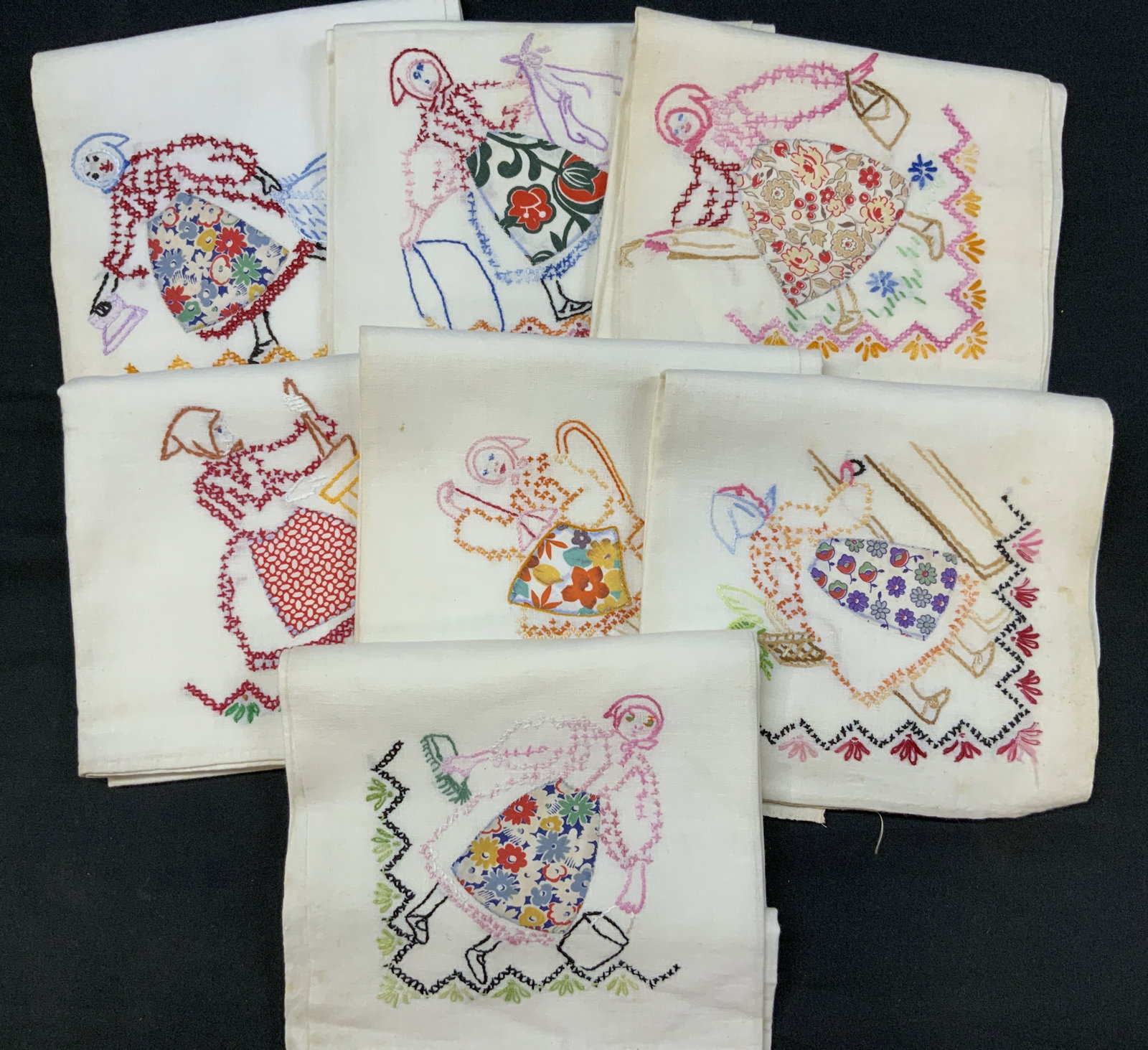 Vtg Applique Embroidered Dutch Girl Linen Set7: Vintage Set of 7 Applique Embroidered Dutch Girl Chores Embroidered Linens. Decorated using combination of hand embroidery and patterned fabric applique on white linen tea towel. Each panel depicting 