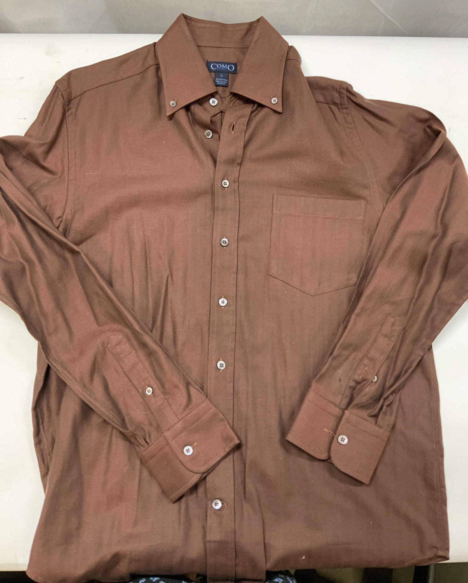 Vntg Como herringbone cotton dress shirt Italy: Vinatge Como herringbone dress shirt. Shirt features a herringbone pattern in a burnt orange color. Made of 100% cotton in Italy. Features a button down collar , a single left chest pocket and irredes