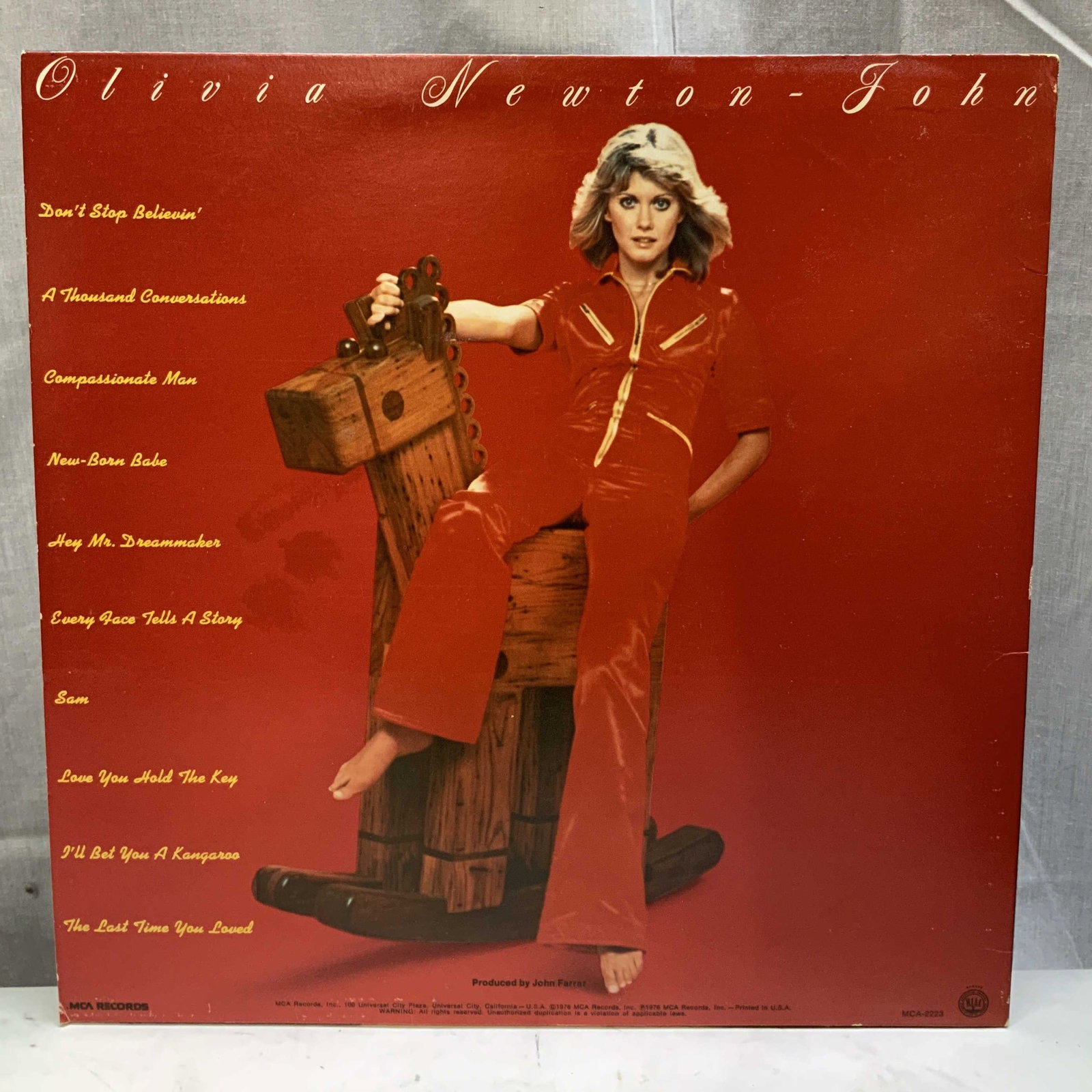 1976 MCA Olivia Newton John Vinyl Record Album: Copyright 1976 MCA Records. Olivia Newton John vinyl record album features song titles on cover. Property of Upper East Side French stage and screen actors estate, Manhattan. Surface wear consistent
