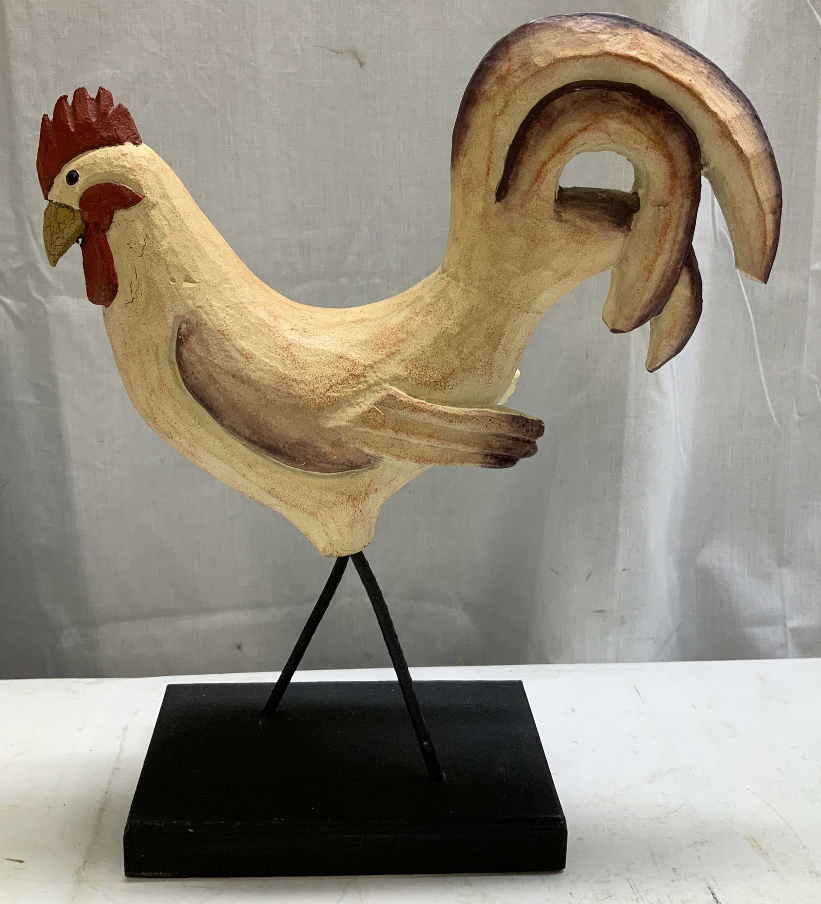 Hand Painted Folk Art Rooster Figurine: Hand painted folk art rooster figurine features a stylized wooden body & is mounted on a rectangular base. Legs are metal. Surface wear consistent to age, use & exposure. Measurements: length 11.2in x