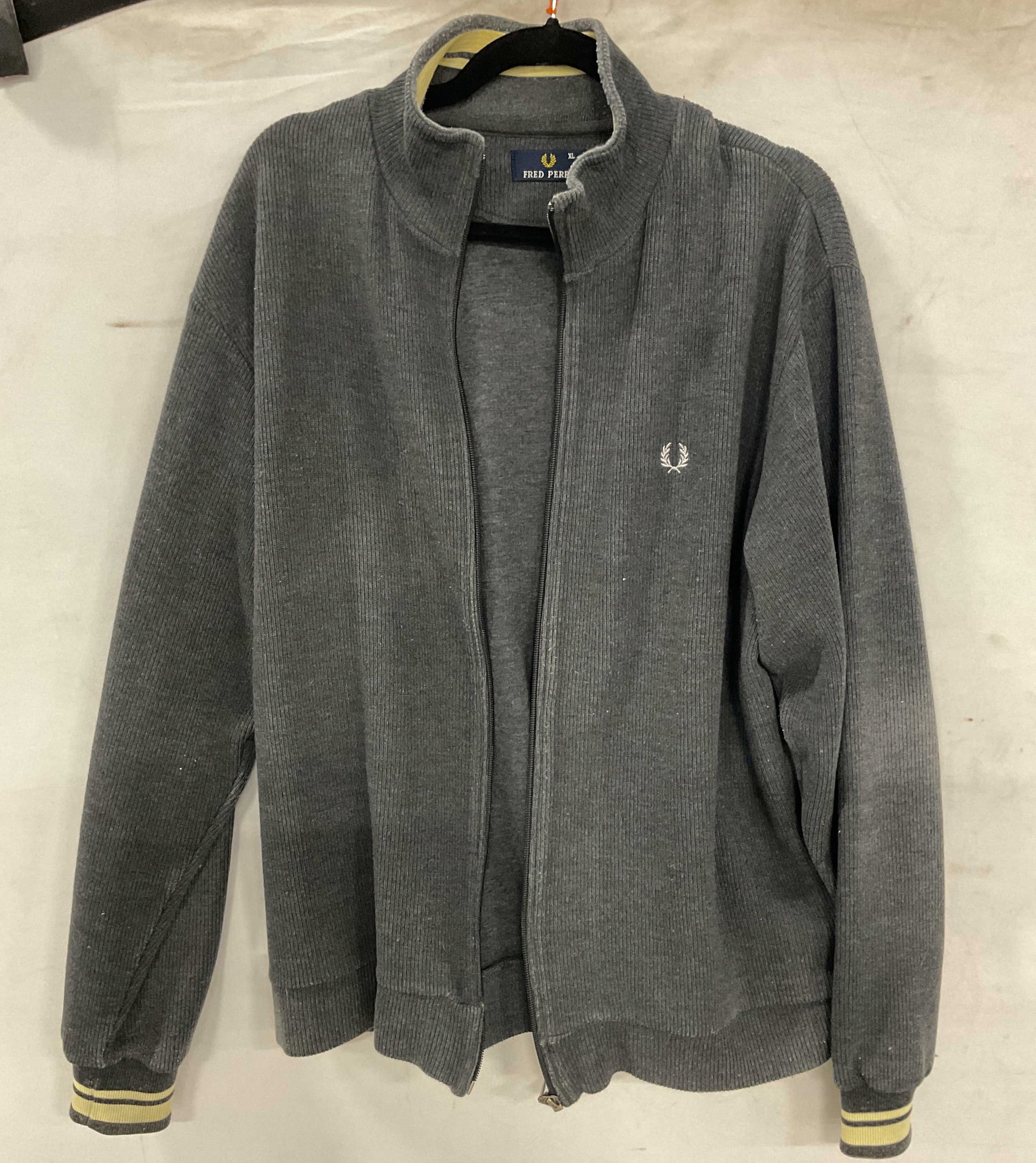 Fred Perry Grey Sweater Zip Up Portugal: Fred Perry grey long sleeve sweater zip up. Made in Portugal. Cotton material. Size XL. Ribbed trim. Zipper in front. Embroidered logo. Surface wear consistent with exposure. Zip up, sweater zip up, F