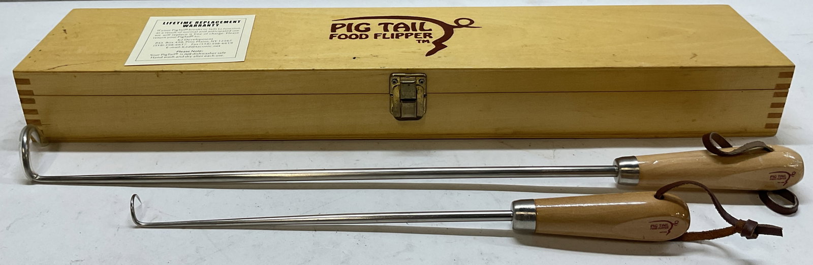 Set 2 Pig Tail Food Flipper With Box: Pig tail food flipper. Comes in rectangular wooden box with logo on lid. Includes two flippers. Wooden handles and sharp pig tail end. Kitchen and barbecue tool. Inside compartments. Size vary. Larges