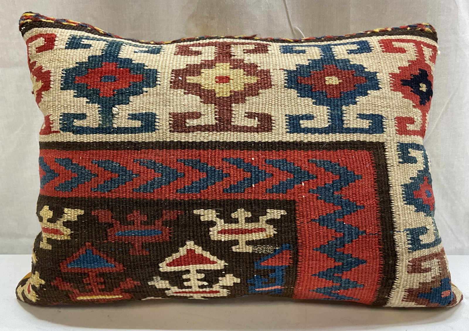 Vintage Turkish Wool Kilim Throw Pillow: Vintage Turkish wool Kilim throw pillow. Geometric tribal like pattern in rich terracotta, blue, and beige tones. Orange yellow back. Measures approx 13 x 18 inches. Surface wear consistent with