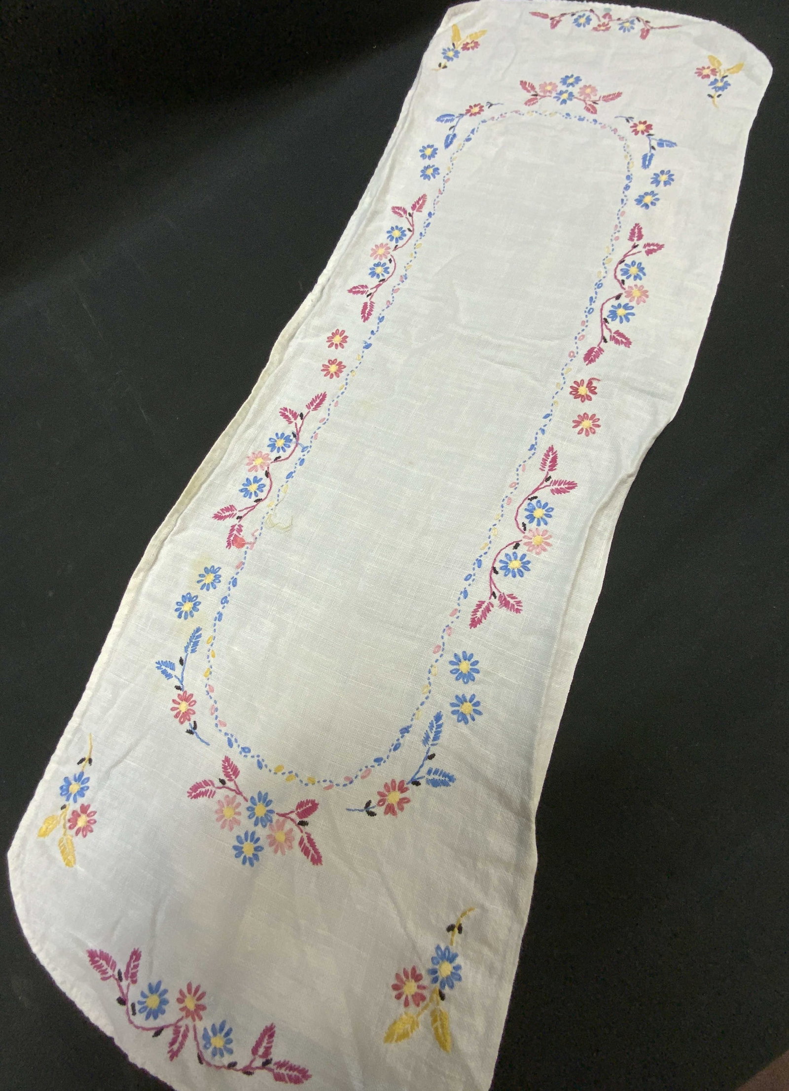 Vtg Hand Embroidered Lazy Daisy Linen Runner: Vintage Hand Embroidered Lazy Daisy Linen Runner. White linen table runner or dresser scarf. Features rounded ends and large central oval frame formed by delicate multi colored running stitches and