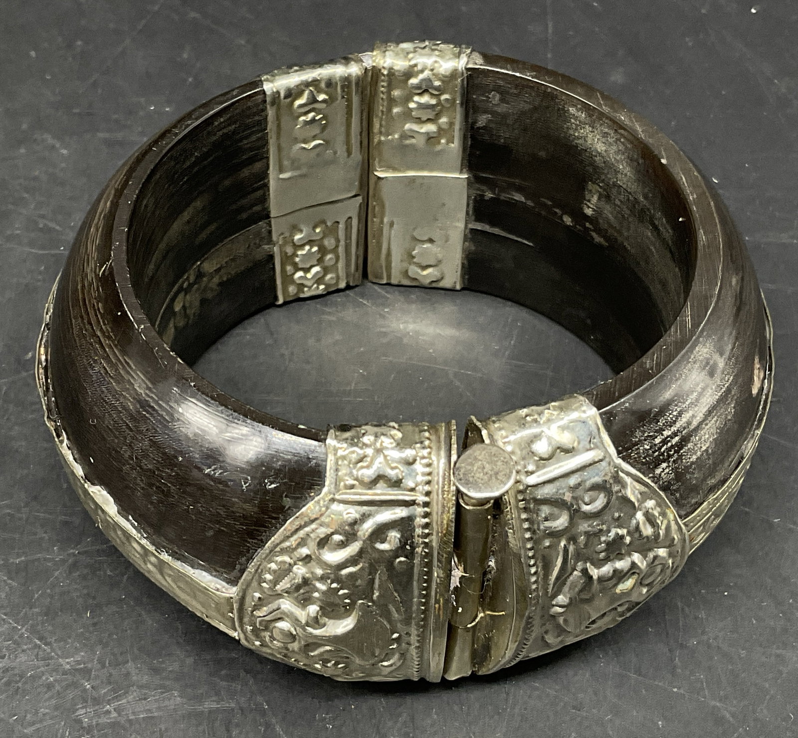 VTG Bohemian Repousse Horn Cuff+ SGND Bag: Vintage Bohemian Silver-Toned Repousse and Black Horn Cuff. Figures, Florals, and Geometric Motifs. Locking Pin Mechanism. Comes with a Signed Alexis Bittar Dust Bag. Scratching and Tarnishing