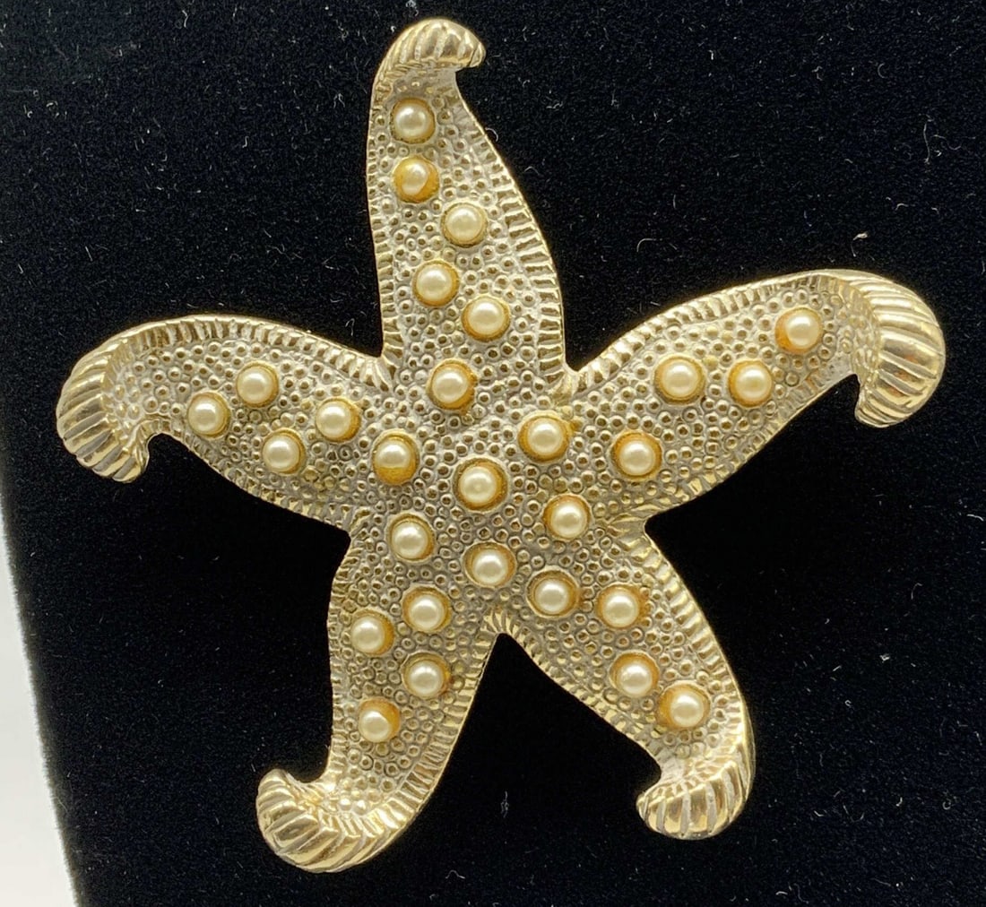 Vtg Gold Tone Starfish Faux Pearl Brooch: Vintage Gold Tone Starfish Faux Pearl Brooch. Costume jewelry brooch designed in shape of five point starfish. Piece is constructed from textured matte gold tone metal featuring curled arm tips with