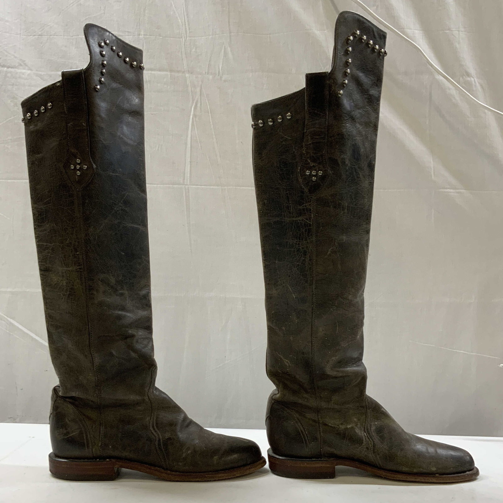 Vntg Lucchese knee high studded boots, USA: Vintage Lucchese knee high studded boots. Size 7.5. Crafted from distressed high grade cowhide leather that develops a unique patina with wear. Finished with distinctive metallic micro stud embellishm
