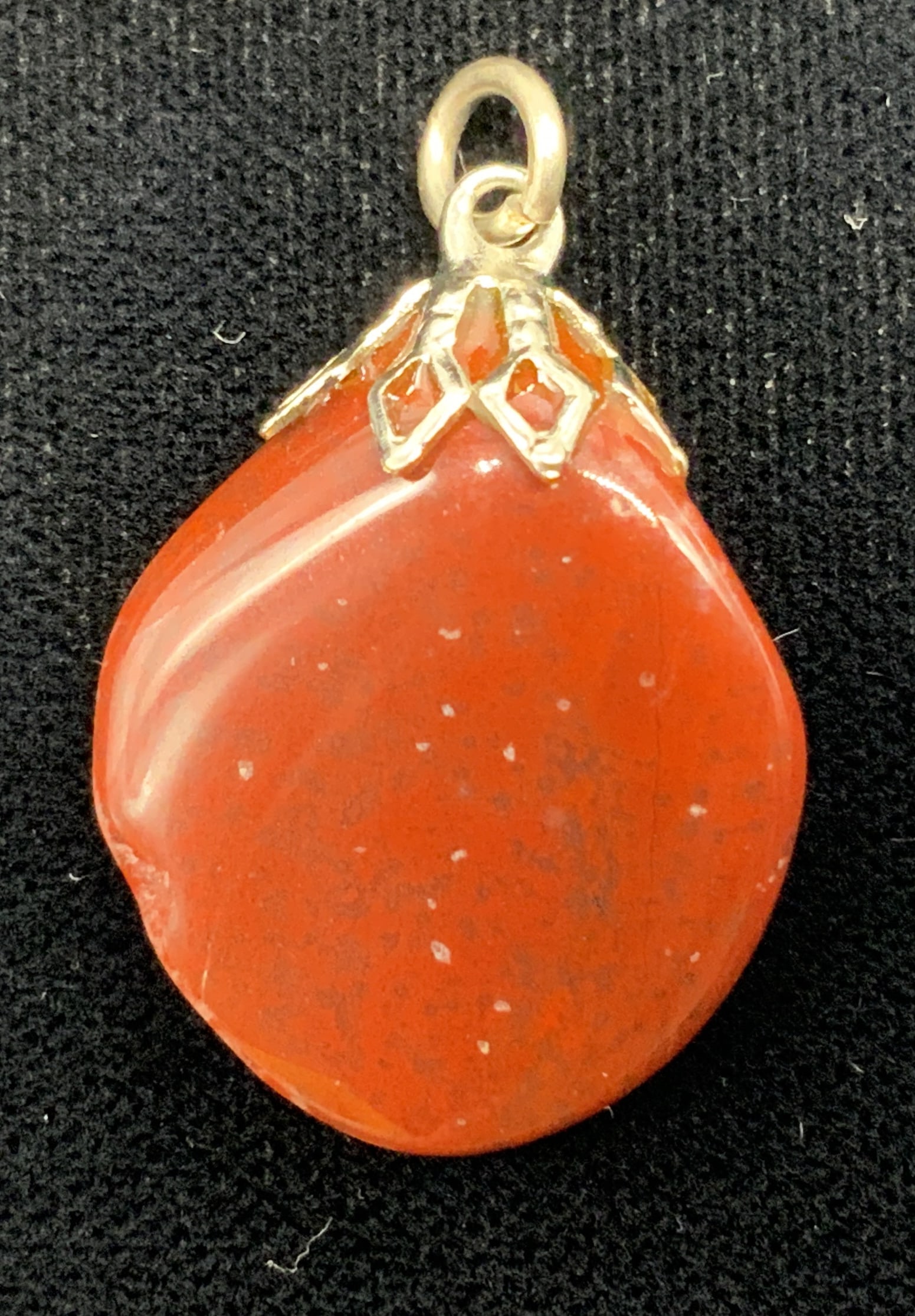 Vtg Semi Precious Stone Pendant: Vintage semi precious stone pendant Tested with Presidium gem tester II. Stone features glossy finish with a brick red coloration and natural inclusions. Mounted at its upper tip with an ornate openwo