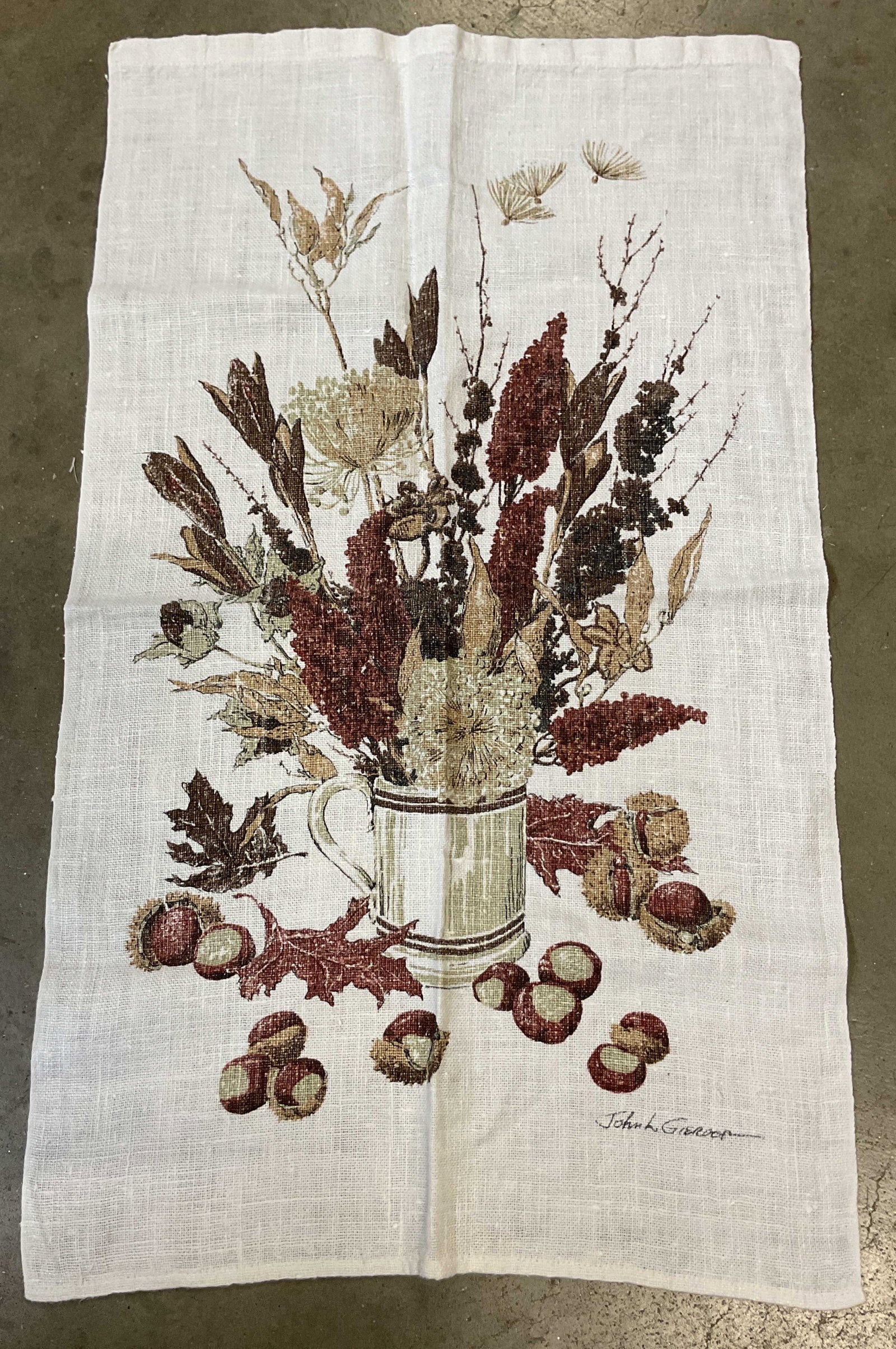 SGND John Gieroch Autumnal Linen Kitchen Towel: John Gieroch autumnal linen kitchen towel. Signed John L. Gieroch. Autumnal floral, leaf, and chestnut still life design. Varying colors. Measures approx 16 x 27.5 inches. Surface wear consistent with