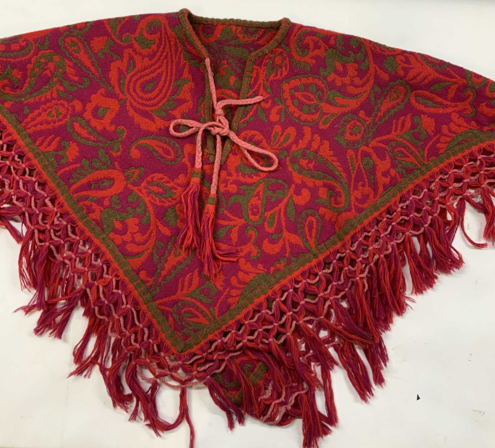 Vntg tapestry fringe poncho. 1960s: Vintage tapestry firing poncho. From the 1960s featuring a distinct bohemian aesthetic. Defined by its ornate paisley pattern woven in a contrasting color scheme and red, purple and green. Includes a
