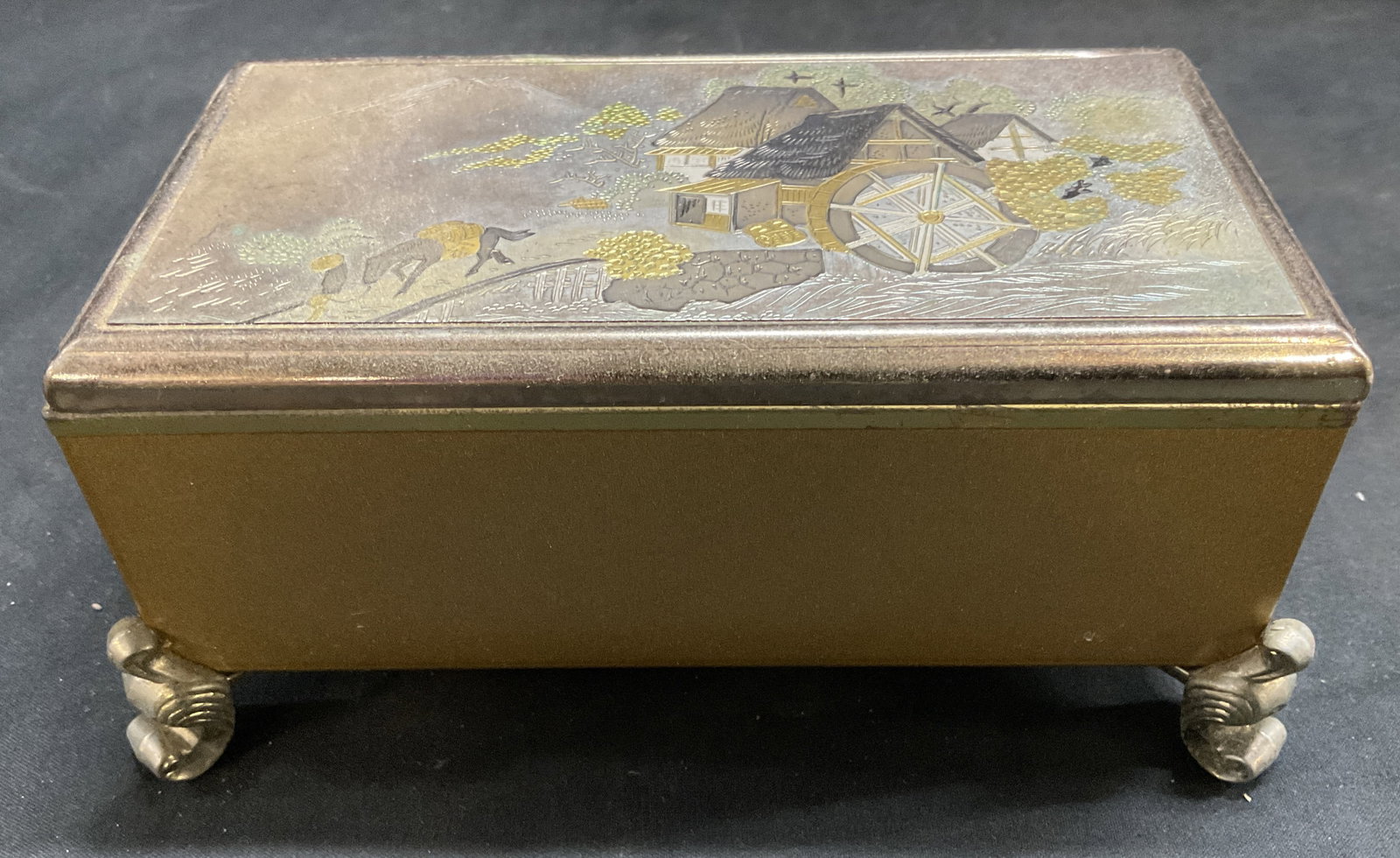 VTG Mixed-Metal Damascene Music Box JAPAN: Vintage Mixed-Metal Damascene Musical Jewelry Box. Japan. Depicts Classic Japanese Rural Landscape Scene with Cottage, Waterwheel, and Mountains. Brass and Silver-Toned Metal. Wind-Up Musical Mechanis