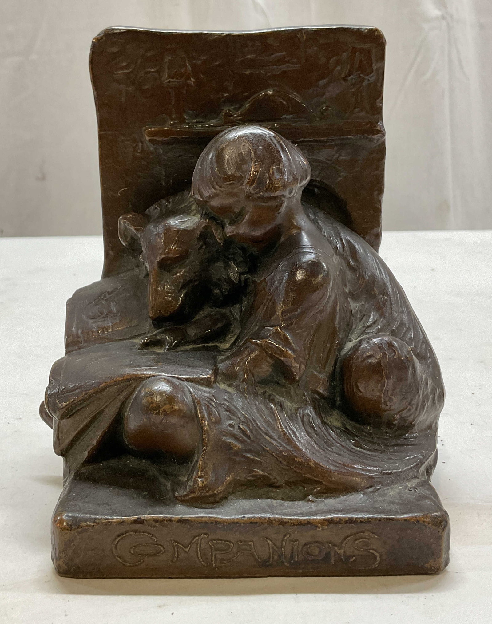 Weidlich Brothers Bronze Clad Companions Bookend: Weidlich Brothers bronze clad Companions bookend. Marked with Weidlich Brothers stamp. Surface reads Companions. Bookend features a young girl sitting with a dog reading next to the fireplace. Detaile