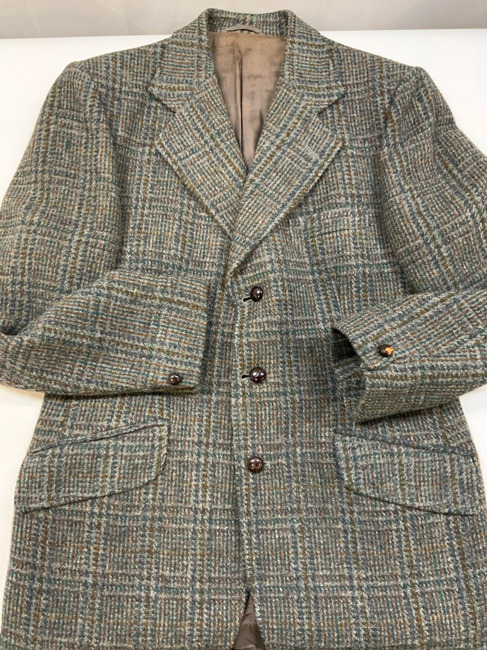 Vntg Dunn& Co, Harris Tweed blazer: Vintage Dunn&Co, Harris Tweed blazer. Made of 100% wool and had woven. Labeled as size 100-measures to app size 40. Jacket features a stripe pattern made if orange and green in a grey textured tweed.