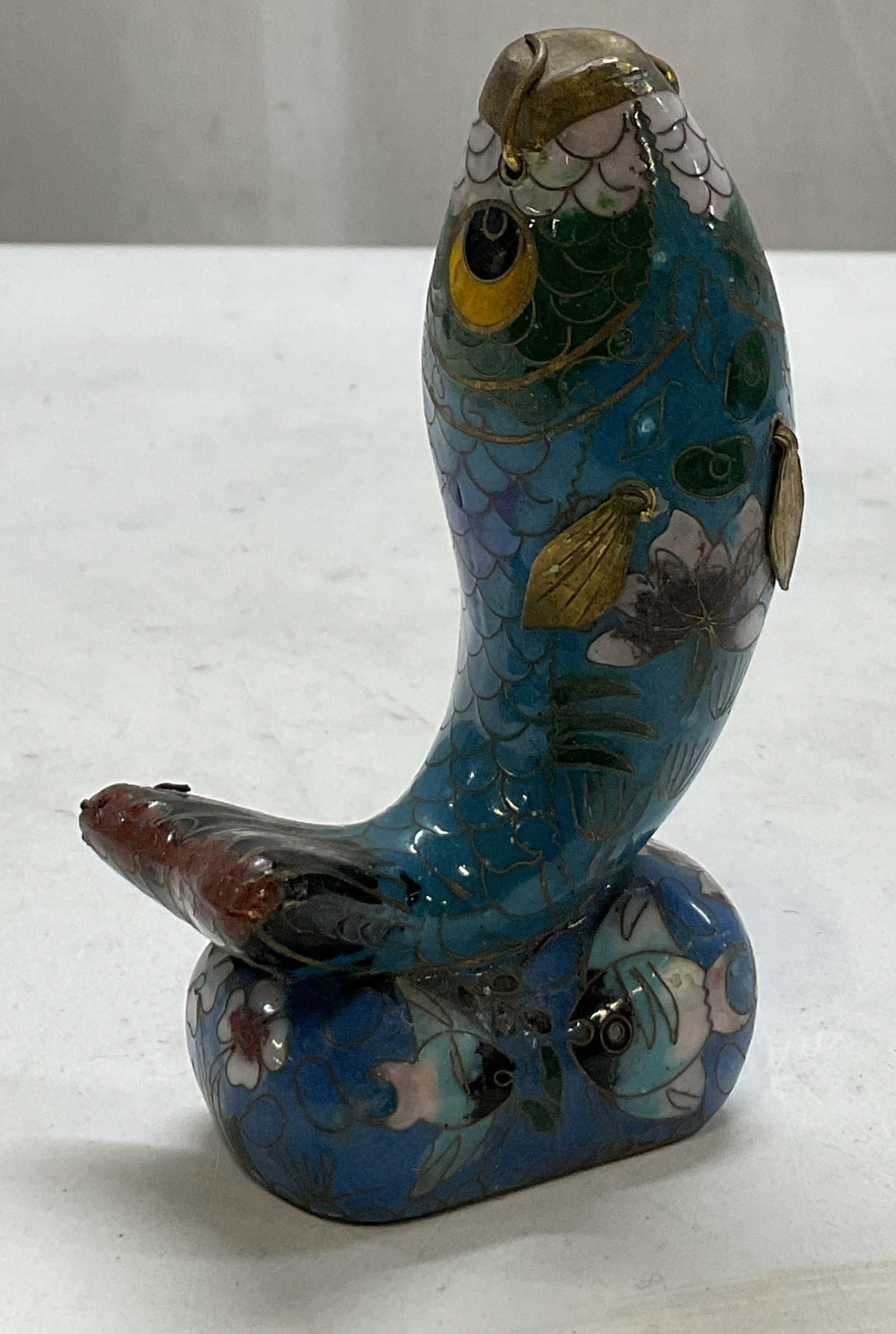 Vintage Chinese Cloisonne Fish Figure: Vintage Chinese cloisonne fish figure. Base features floral and fish motifs in varying colors. Enameled brass. Figure is in a curved upright pose. Detailed features and textures. Gilt accents. Measure