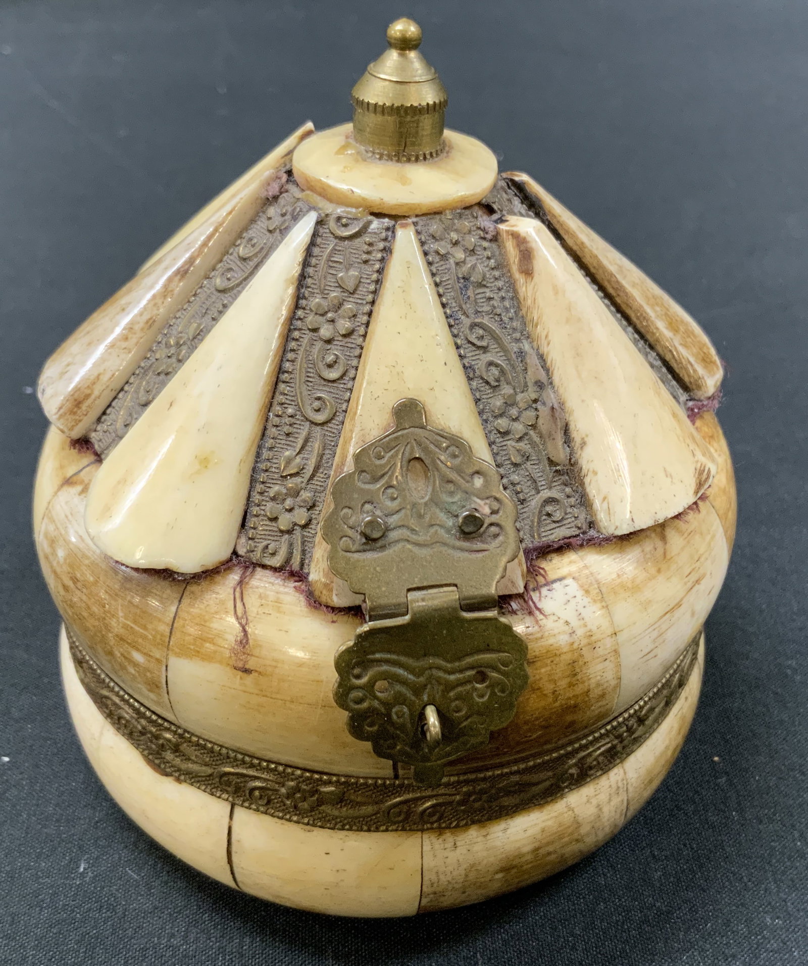 Vtg Bone & Brass Carousel Trinket Box: Vintage pieced bone & brass carousel trinket box. Exterior constructed by pieced bone panels arranged in carousel or tent shape. Accented by floral embossed brass bands and trim panels. Ornate brass l