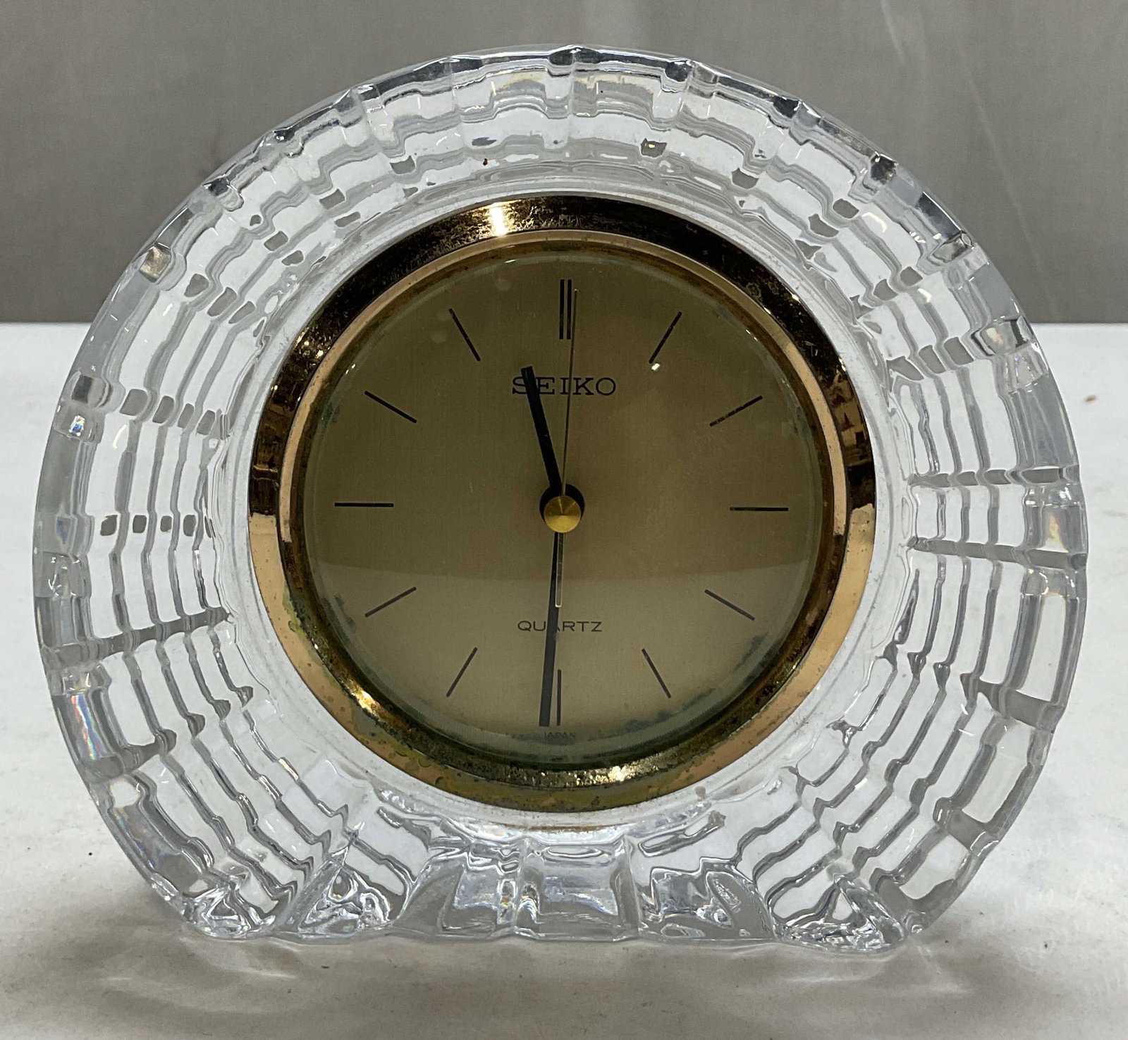 Seiko Arch Shaped Crystal Mantle Clock Japan: Seiko arch shaped crystal mantle clock. Marked Japan. Gold toned dial. Heavy cut faceted body with arch. Ribbed surface. Measures approx 2 x 6 x 5 inches. Not tested for function, sold as is. Scratchi