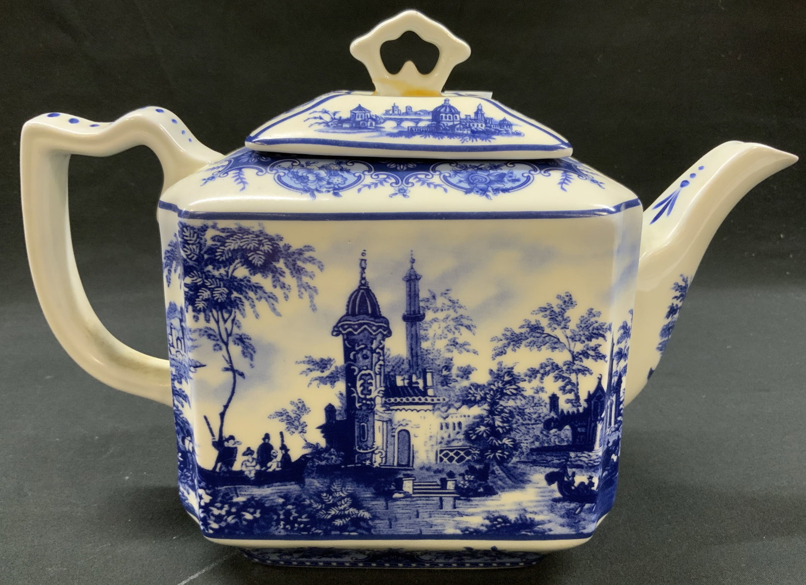 Vtg English Blue & White Square Teapot: Vintage English ceramic blue and white square body Transferware teapot. Display pastoral landscape scenes. Ornate floral, leaf, and scrollwork borders trim upper Shoulders and matching lid. Underside