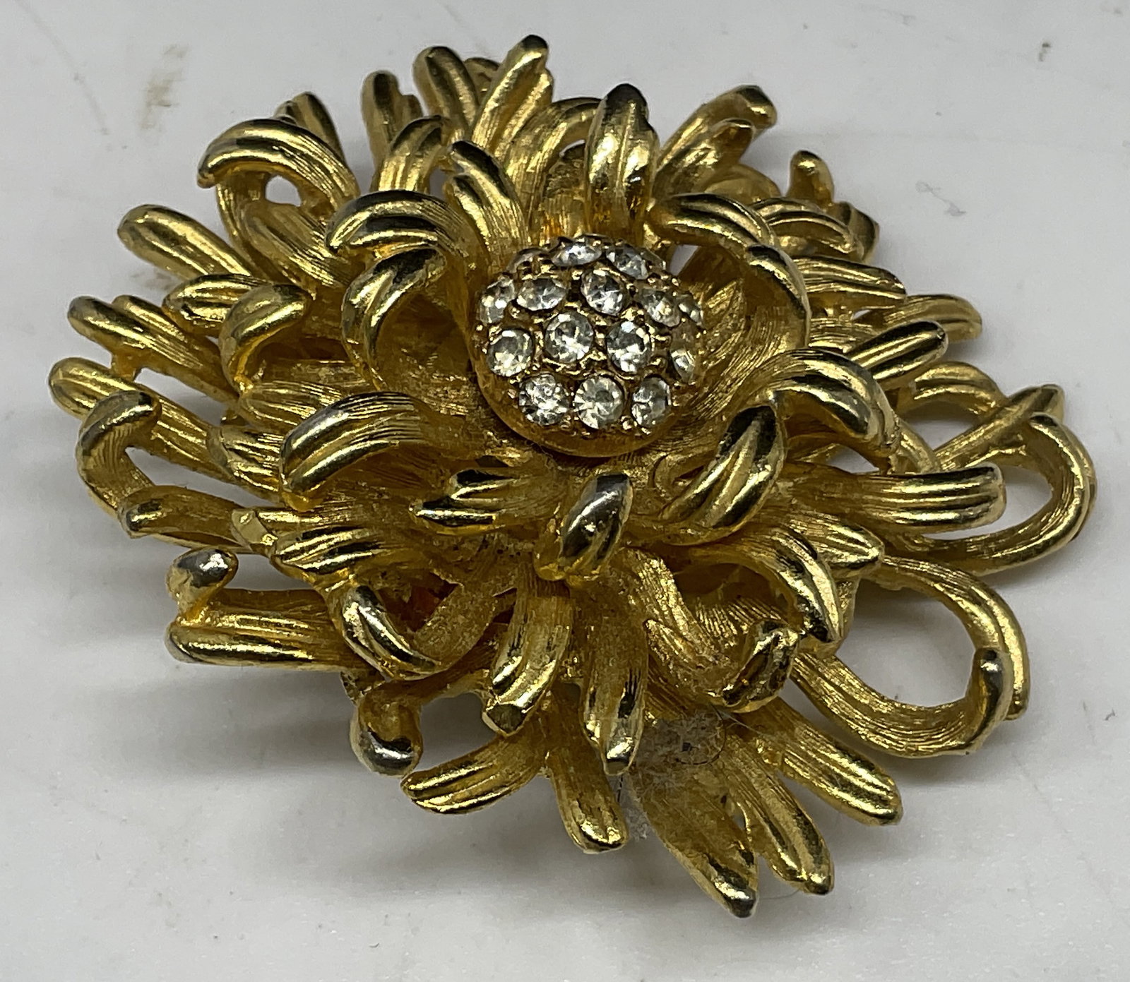 VTG Layered Gold-Toned Chrysanthemum Brooch: Vintage Layered Gold-Toned Chrysanthemum Flower Brooch. Clear rhinestone accents. Condition consistent with age and exposure. Measures approx 1.5in Diam. vintage, rhinestones, gold-toned, brooches,