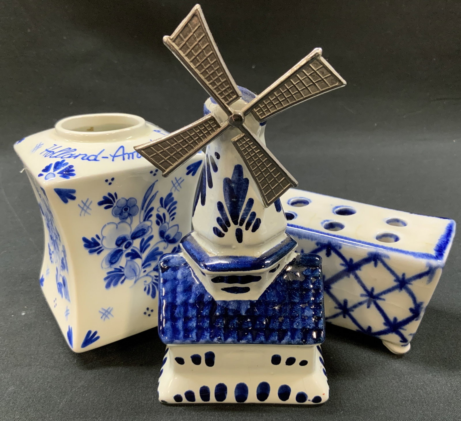 Vtg Lt3 Holland Porcelain Figurines: Vintage lot of 3 Holland Porcelain Figurines. Includes: 1x windmill, 1x square vase, 1x five hole flower brick frog container with crosshatch lattice pattern. Square vase marked Holland America Line, 