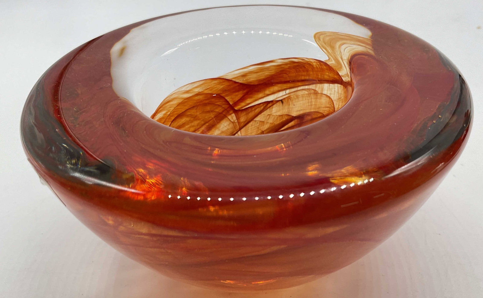 Kosta Boda Atoll Swirl Art Glass Bowl: Label affixed to bowl, Kosta Boda Atoll red and amber swirl art glass votive holder, bowl, decorative accessory, designed by Anna Ehrner, featuring vibrant fiery ribbons encased in heavy hand blown cl