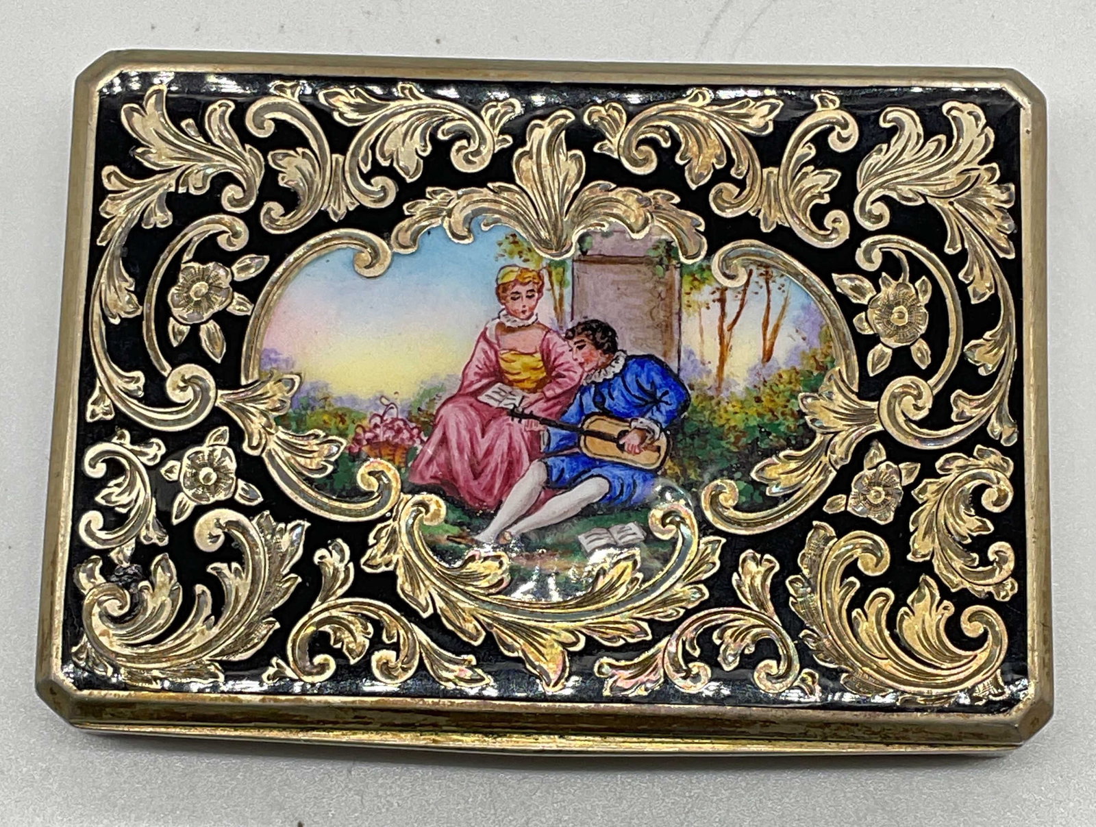 1930 Sterling Silver Enamel Trinket Box Austria: Circa 1930 sterling silver trinket box. Hand enameled black panels with ornate chased scroll lid and central courting couple scene. Gold plated interior. Inscribed on interior with date 1930. Marked s