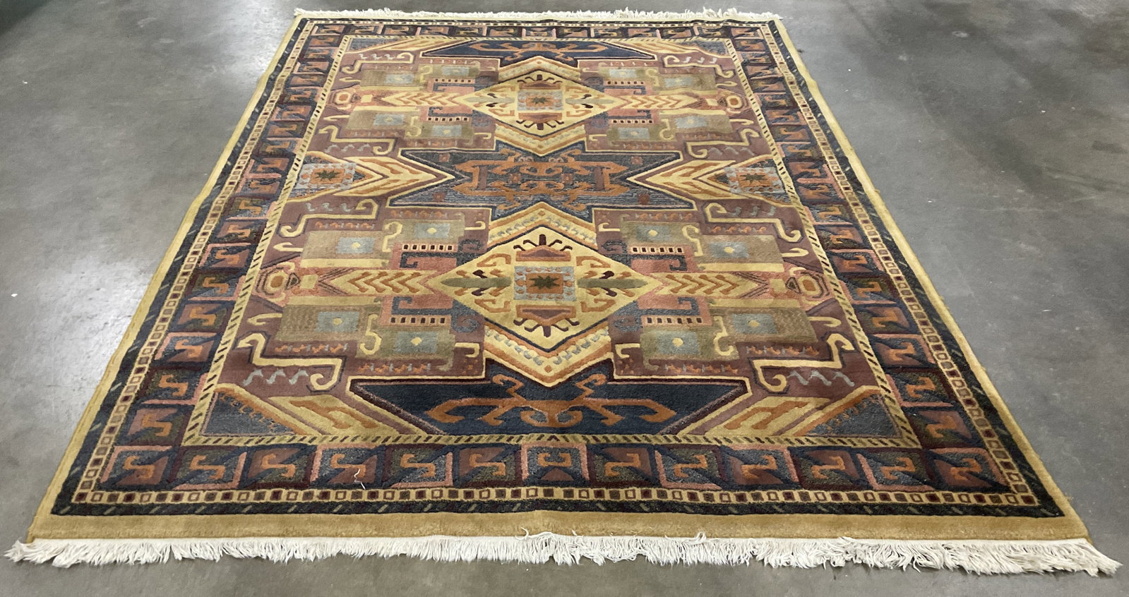 VTG Persiana Worsted Wool Fringed Area Rug BELG: Vintage Persiana Worsted Wool Area Rug. Intricate, Multi-Toned Geometric Design Inspired by Traditional Kazak and Southwestern Motifs. Framed by Distinct Yellow Border. Cream Colored Fringe on Edges. 