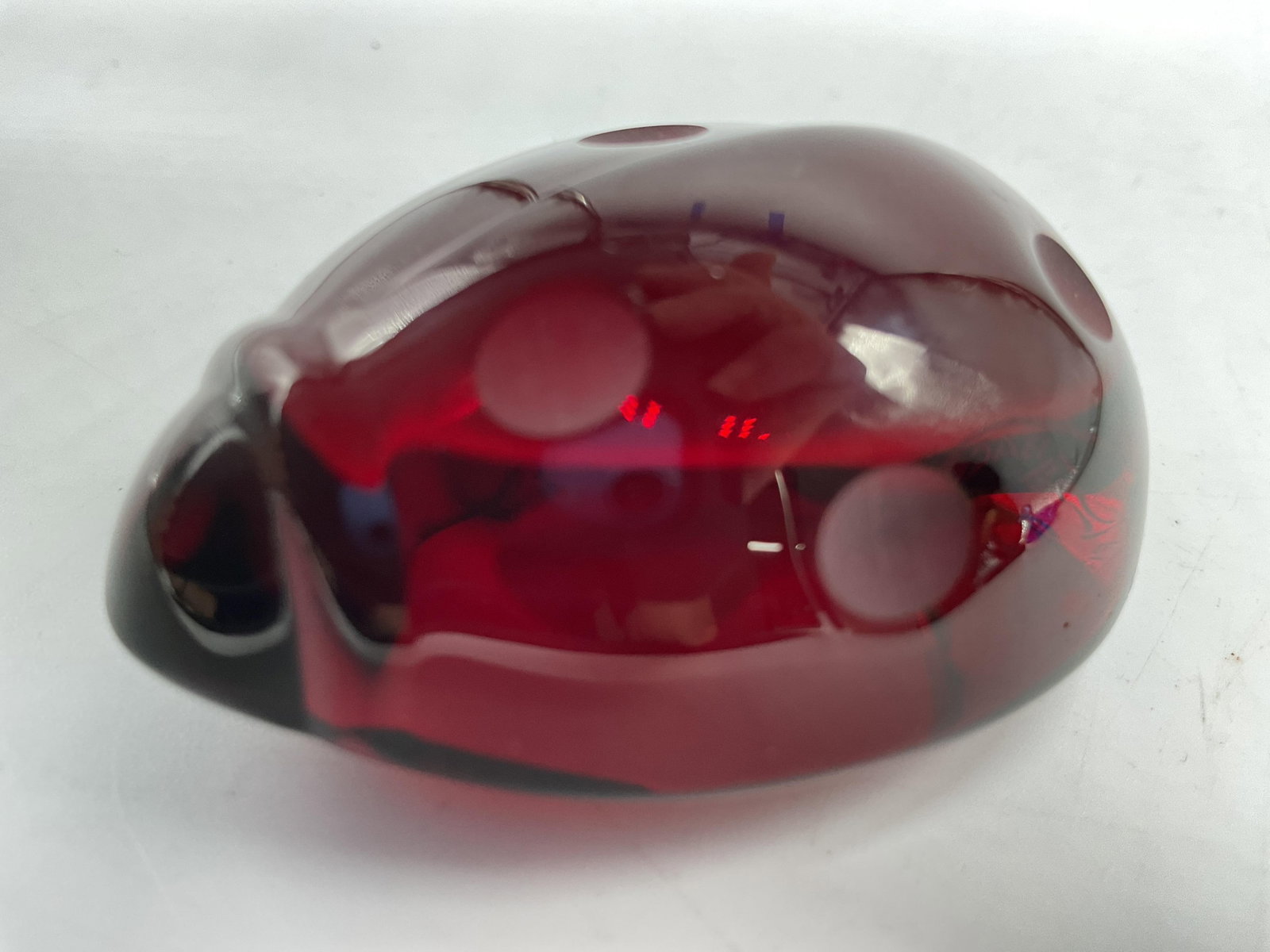 Baccarat Crystal Ruby Red Ladybug Paperweight: Baccarat France signed Crystal Ruby red lady bug paperweight , featuring a rich ruby red hue, characteristic frosted circular spots bd a molded silhouette, measures app 2.5 inches, lc