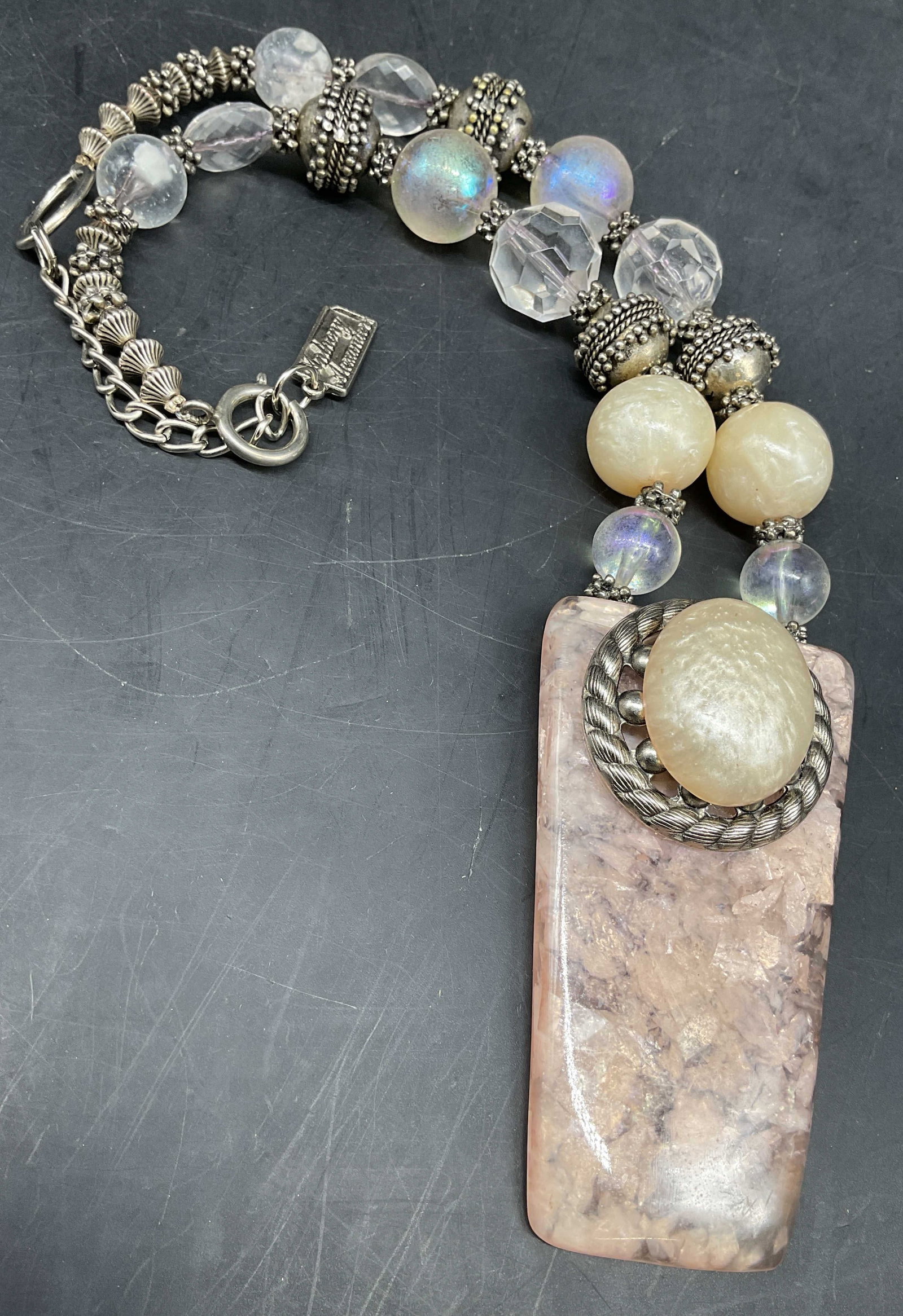 Anthony Alexander Vntg Statement Stone Necklace: Vintage signed Anthony Alexander Statement necklace features iridescent art glass beads and a large stone pendant accented with a decorative silver tone circular frame, hand crafted by couture designe