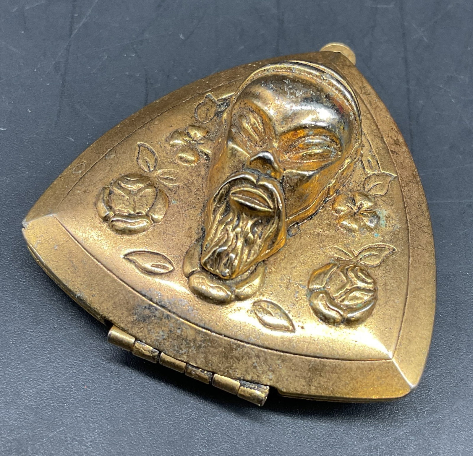 Gold Tone Asian Mask Locket Jewelry: Vintage gold toned triangular locket pendant features a repousse stylized bearded Asian face mask surrounded by floral motif, vintage jewelry, estate jewelry, closed measures app 1.75 by 1.25 inches