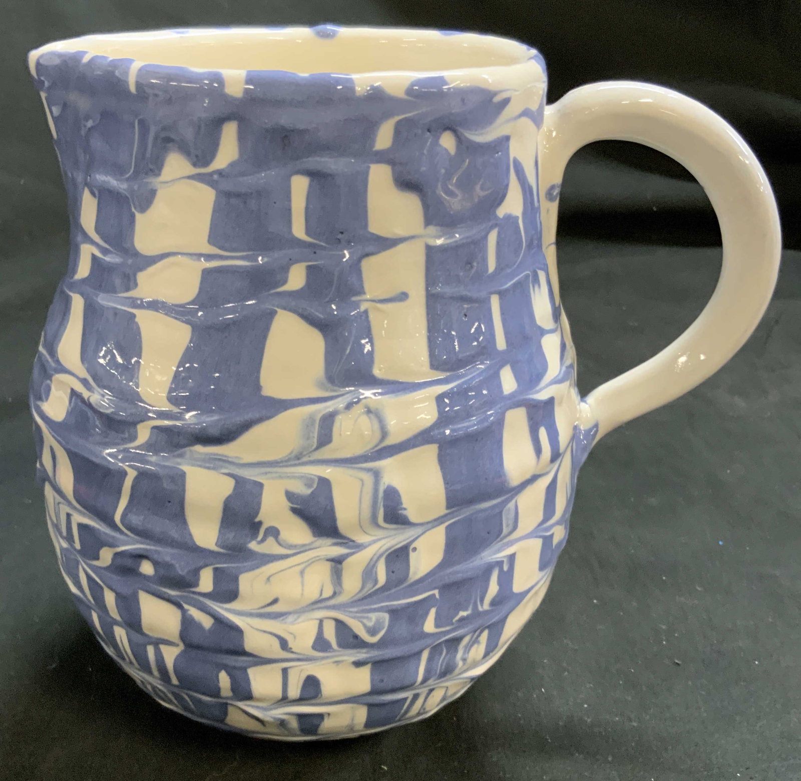 Marbled Blue and White Signed. Ceramic Pitcher: Signed illegibly on underside dated 2013, pitcher, vase, features a glossy cream base adorned with a fluid marbled blue and white splatterware and slip design with a subtly ribbed body, measures ht ap