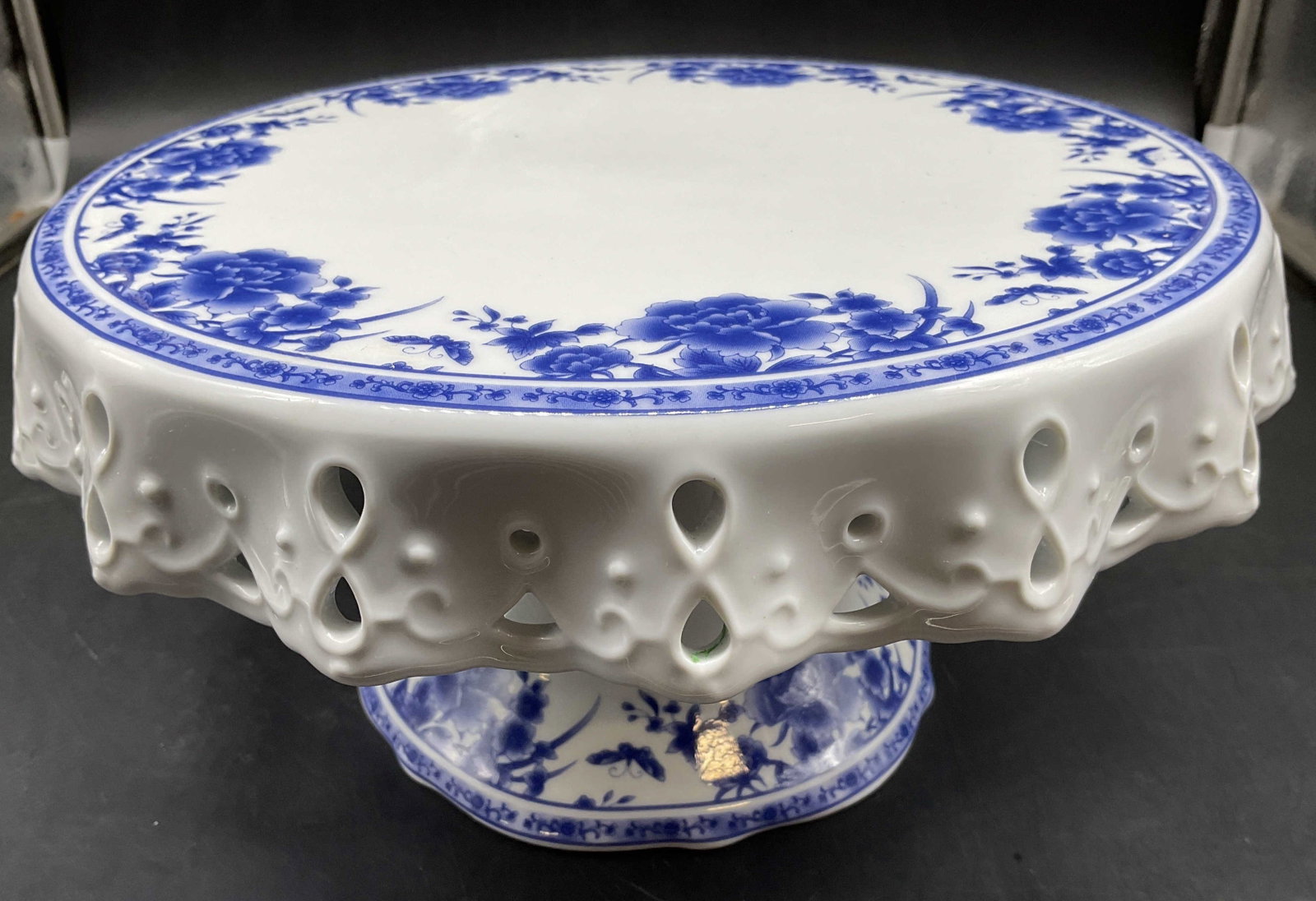Vntg Blue White Porcelain Cake Stand: Vintage blue and white porcelain cake stand, blue and white floral and geometric border, open Lace Style side border, measures ht app 5.5 inches, diameter app 10 inches, missing part of center