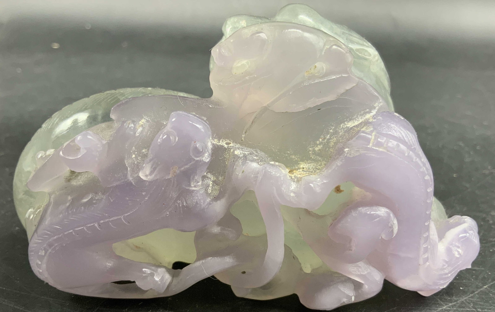 Crvd Lavender Green Jadeite Dragon Fig: Carved lavender and pale green jadeite sculpture with dragons and mythical figures, opaque and semi translucent sections, natural color variations, measures ht app 3 inches length app 5 inches depth