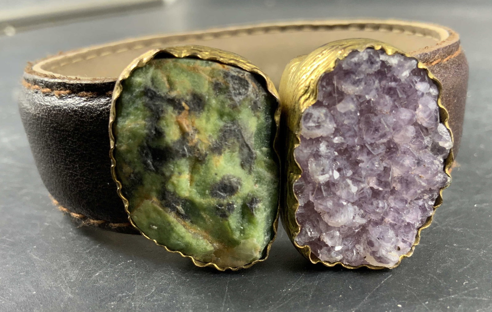 Bohemian Dual Stone Leather Cuff Bracelet: Bohemian dual stone leather cuff bracelet featuring a Elen set with a sparkling Amethyst geode crystal druzy stone, alongside a contrasting green mottled epidote gemstone, both enclosed in textured go