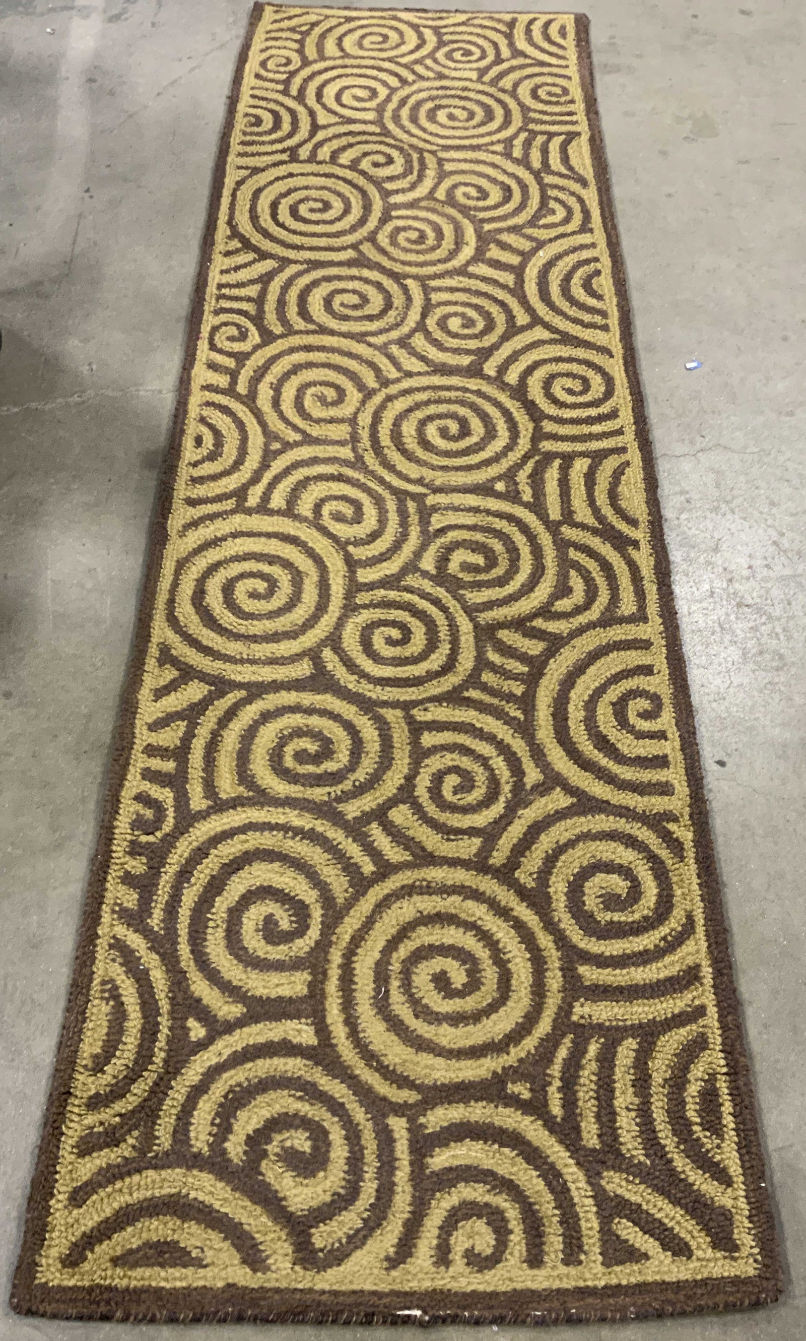 Contemporary Spiral Wool Carpet Runner, India: Contemporary brown and wheat toned spiral design wool carpet, label affixed verso reads made in India, carpet runner measures 95 by 27 inches, has wear, has backing