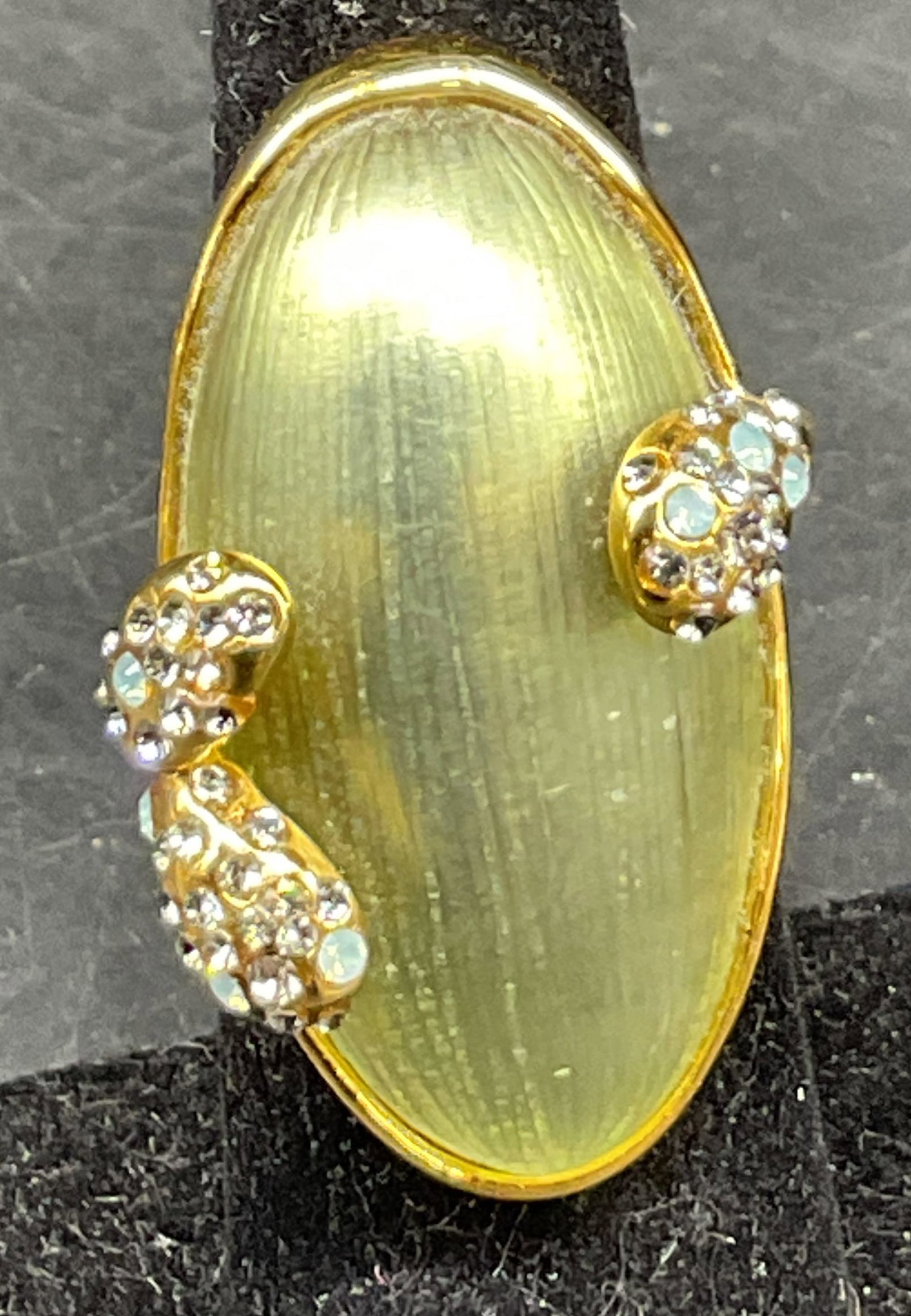 Vtg Alexis Bittar Hand Carved White Lucite Ring: Vintage Alexis Bittar hand carved white lucite ring. Gold toned band. White greenish carved center. Oval shaped. Accented with sky blue and clear Swarovski crystals. Measures approx size 7. Scratching