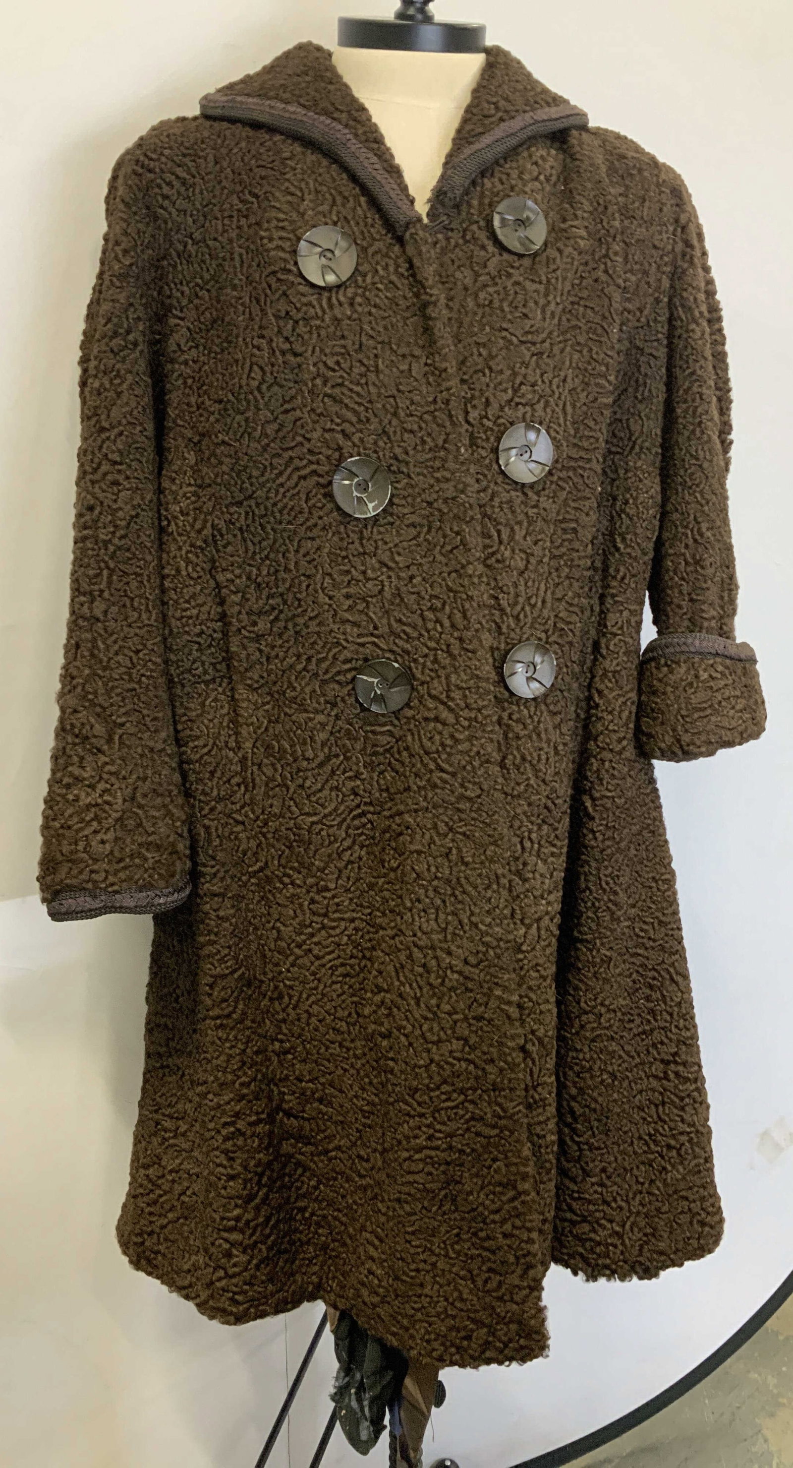 Vntg ARNOLD CONSTABLE curly lamb coat: Vintage ARNOLD CONSTABLE curly lamb coat. Made of curly lambs wool to give the coat texture. The coat utilizes a formal six button double breasted layout. The large stylized buttons feature a geometri