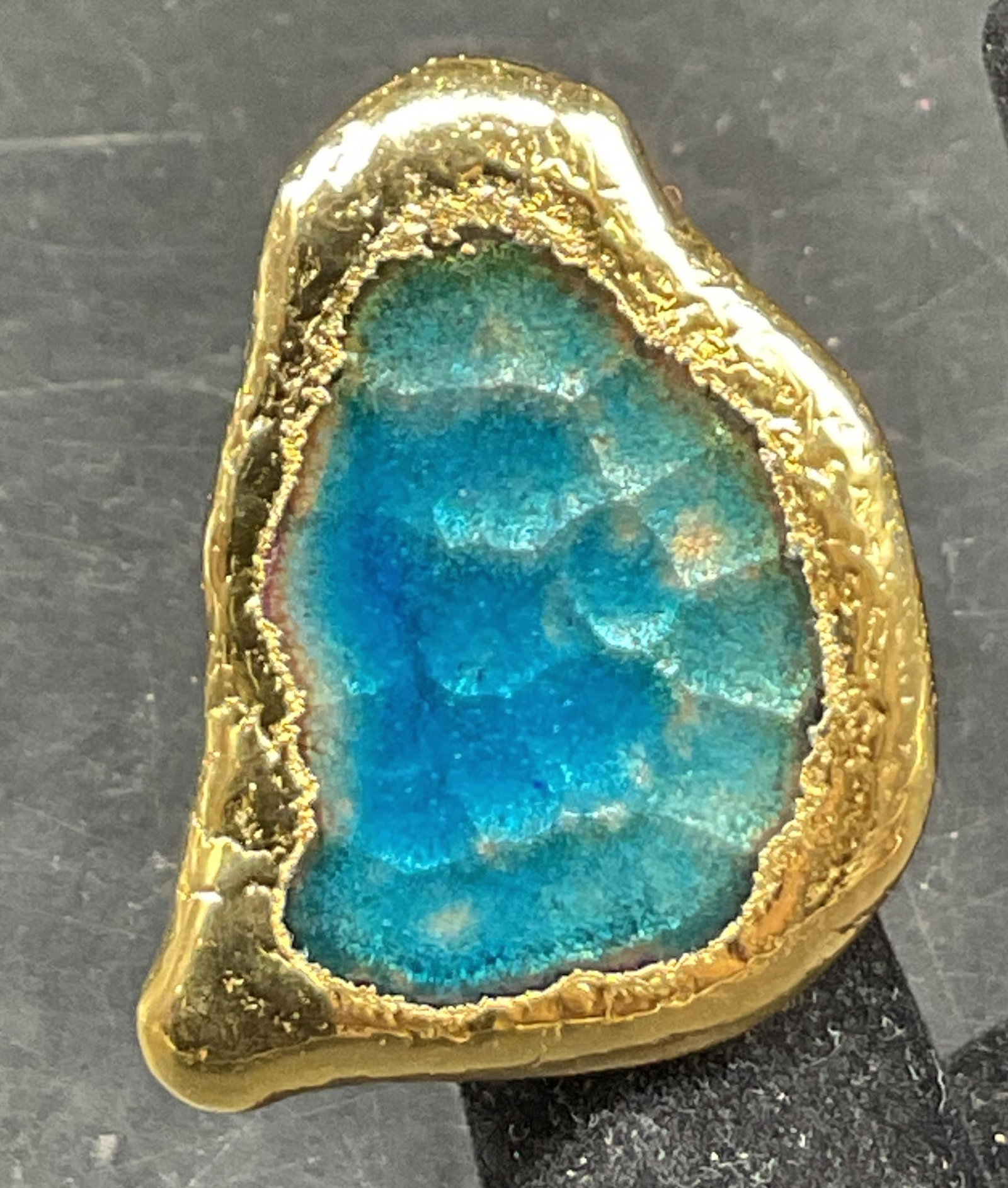 Vtg Blue Semiprecious Gold Toned Statement Ring: Vintage blue semiprecious gemstone gold toned statement ring. Tested with Presidium Gem Tester II. Unique shape, blue semiprecious gemstone in center. Textured gold toned. Measures approx size 5. Scra