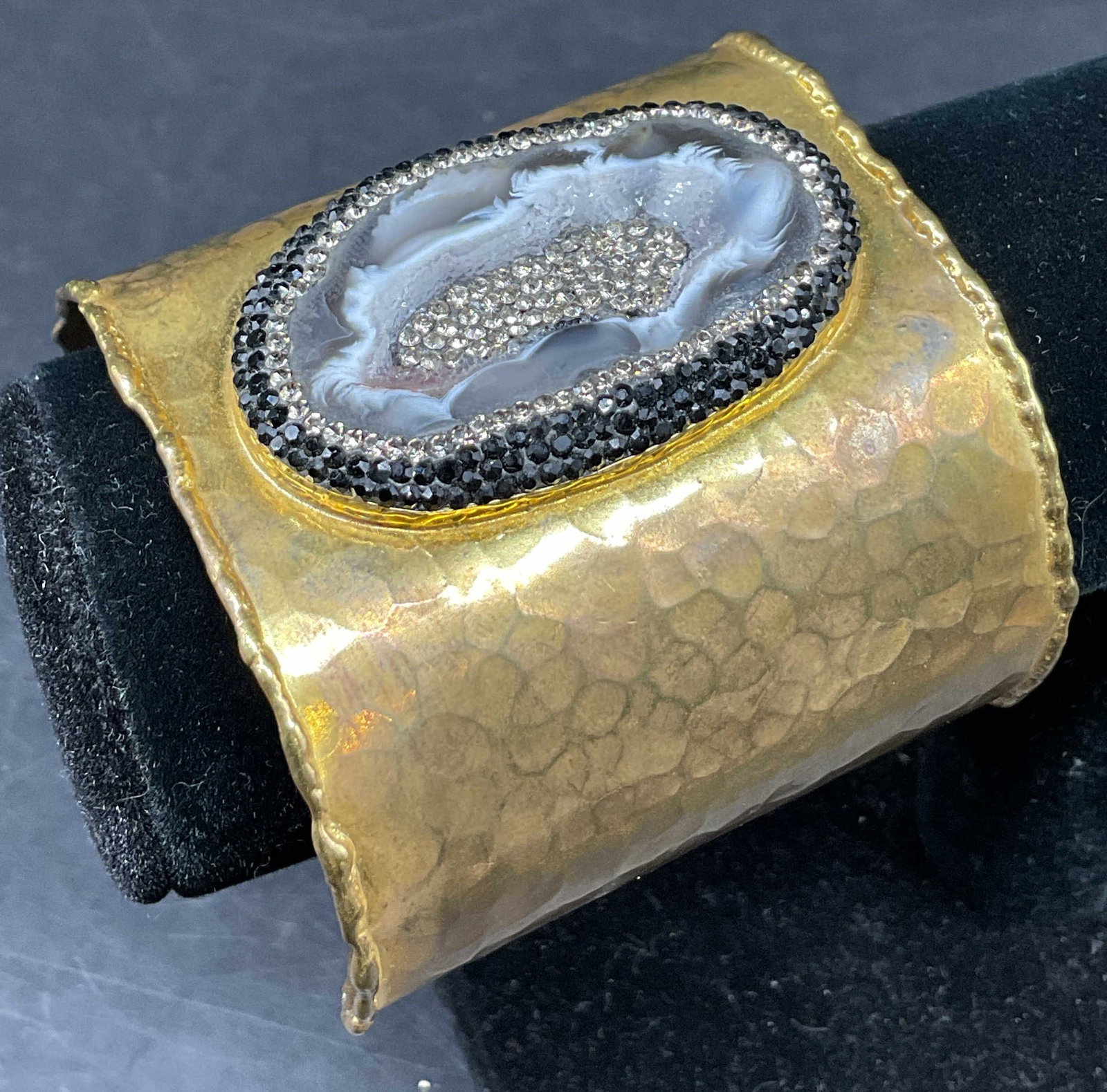Vintage Gold Toned Semiprecious Cuff Bracelet: Vintage gold toned semiprecious gemstone cuff bracelet. Hammered gold toned band, textured. White and black semiprecious gemstone in center accents with clear and black rhinestones. Tested with