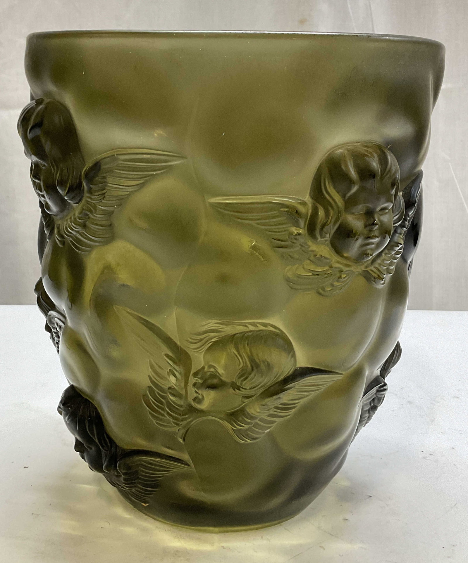 Art Deco Glass Curt Schlevogt Cherub Vase: Art Deco glass Curt Schlevogt cherub vase. Greenish grey color. Embossed cherub faces motifs. Detailed features and textures. Measures ht approx 9 inches diam approx 8 inches. Scratching. Curt Schlevo